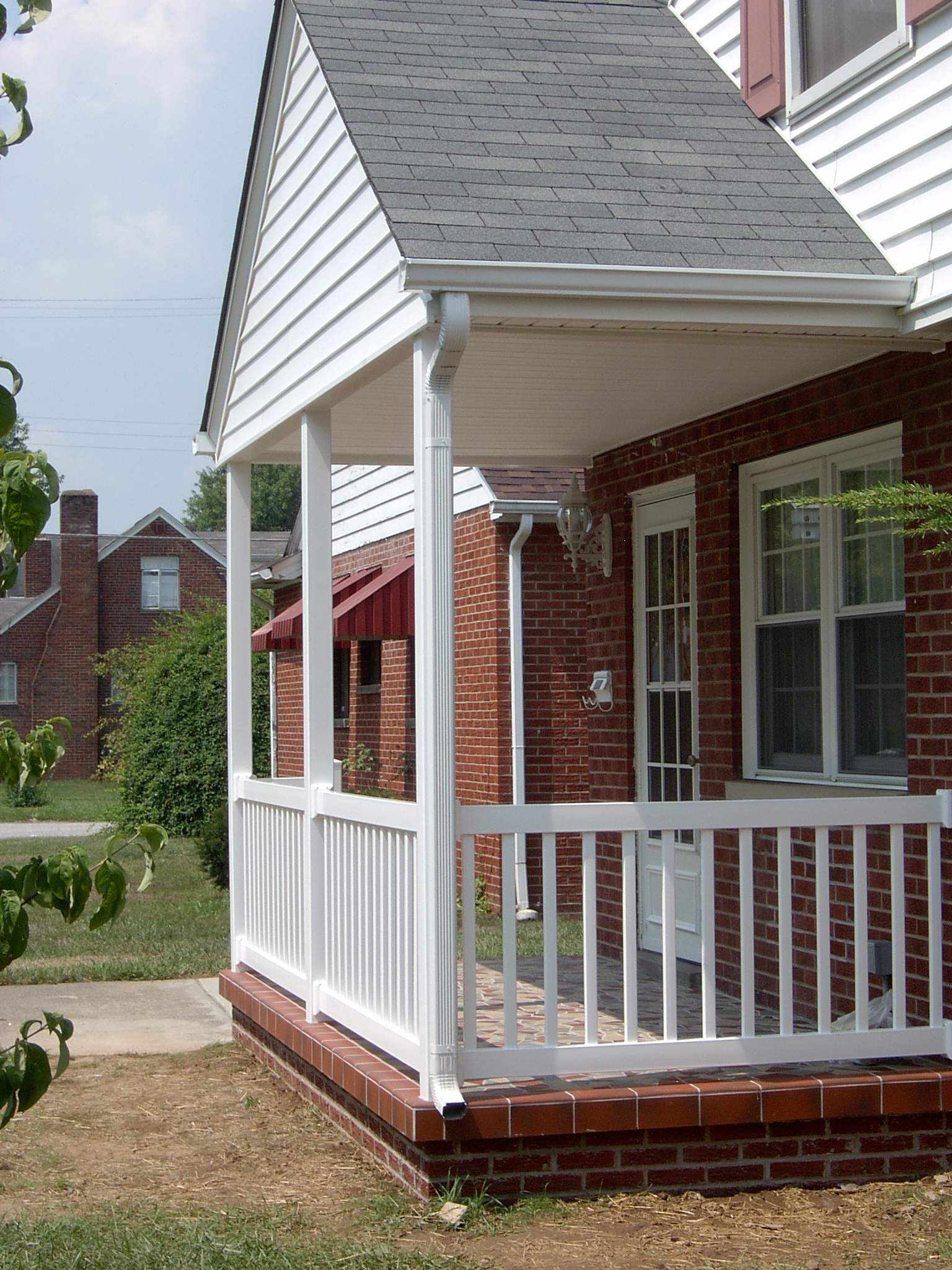 New front porch build, with tile floor and vinyl railing. by Secure Construction Company Inc