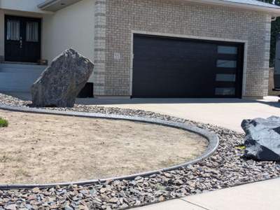 Custom Stamped Concrete Curbing and Decorative Rock Bed Installation by Pump it Up Concrete Jacking