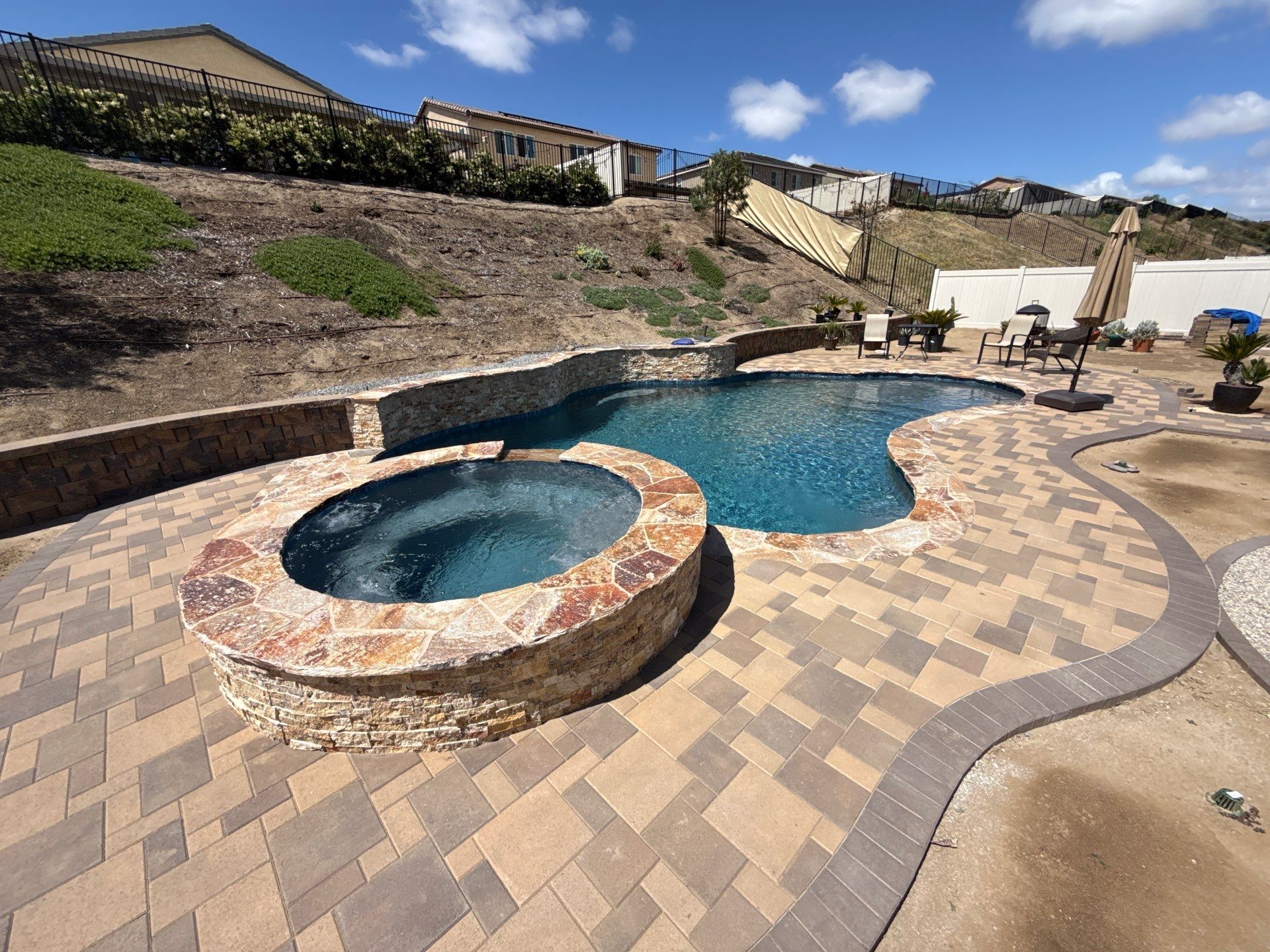 Freeform pool and spa with paver decking by Premier Pools and Spas Temecula