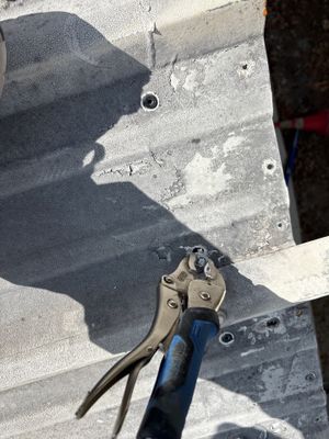 Close up of metal roof panel with locking pliers