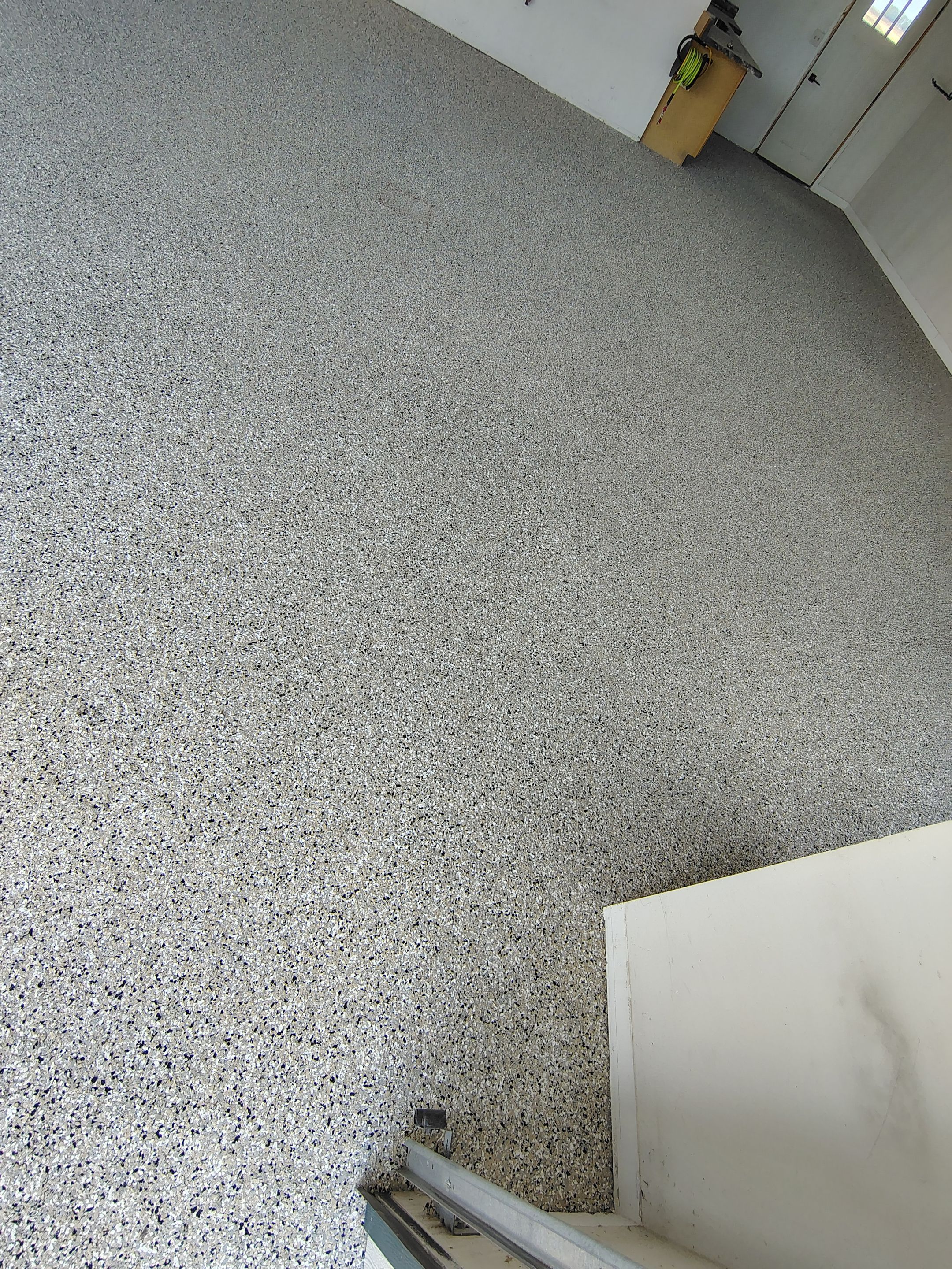 Speckled Polyaspartic Garage Floor Coating Installation in Dell Rapids by Select Painting, Coatings & Garage Cabinets