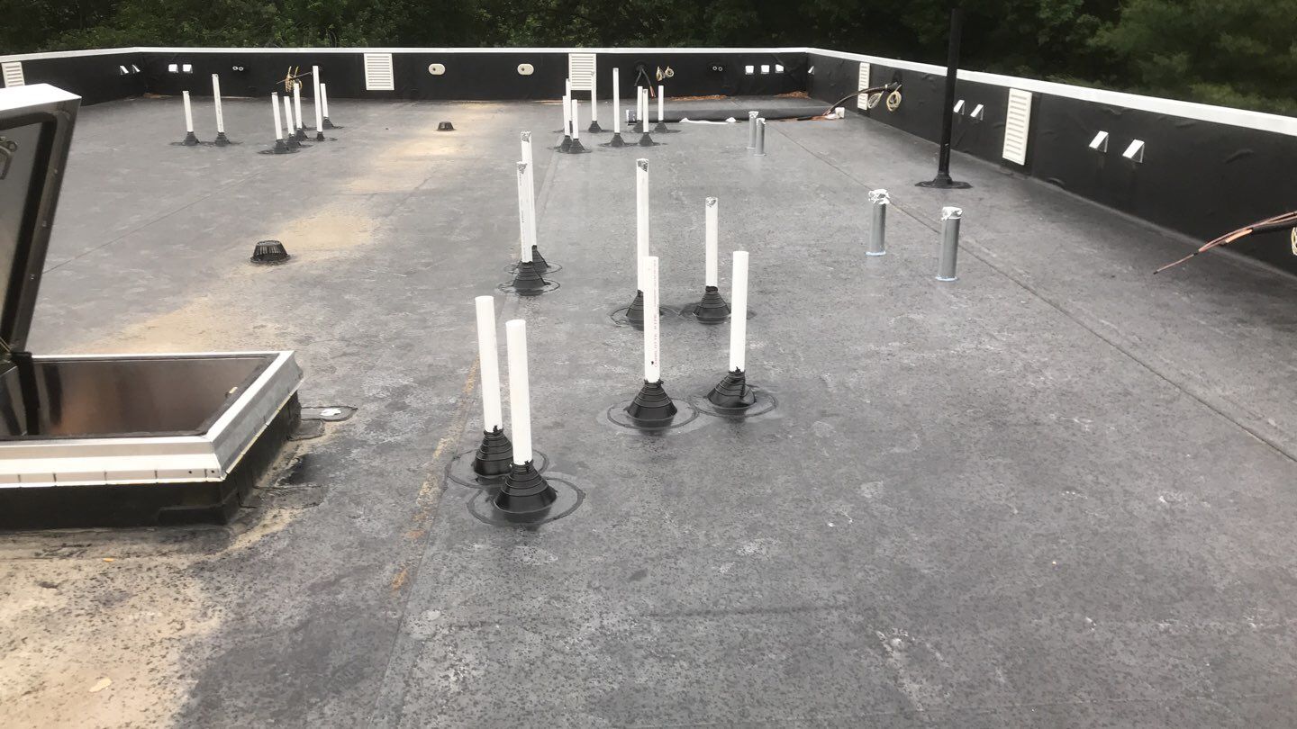 Commercial Roofing Installation using EPDM with white gutters by A Plus Exterior