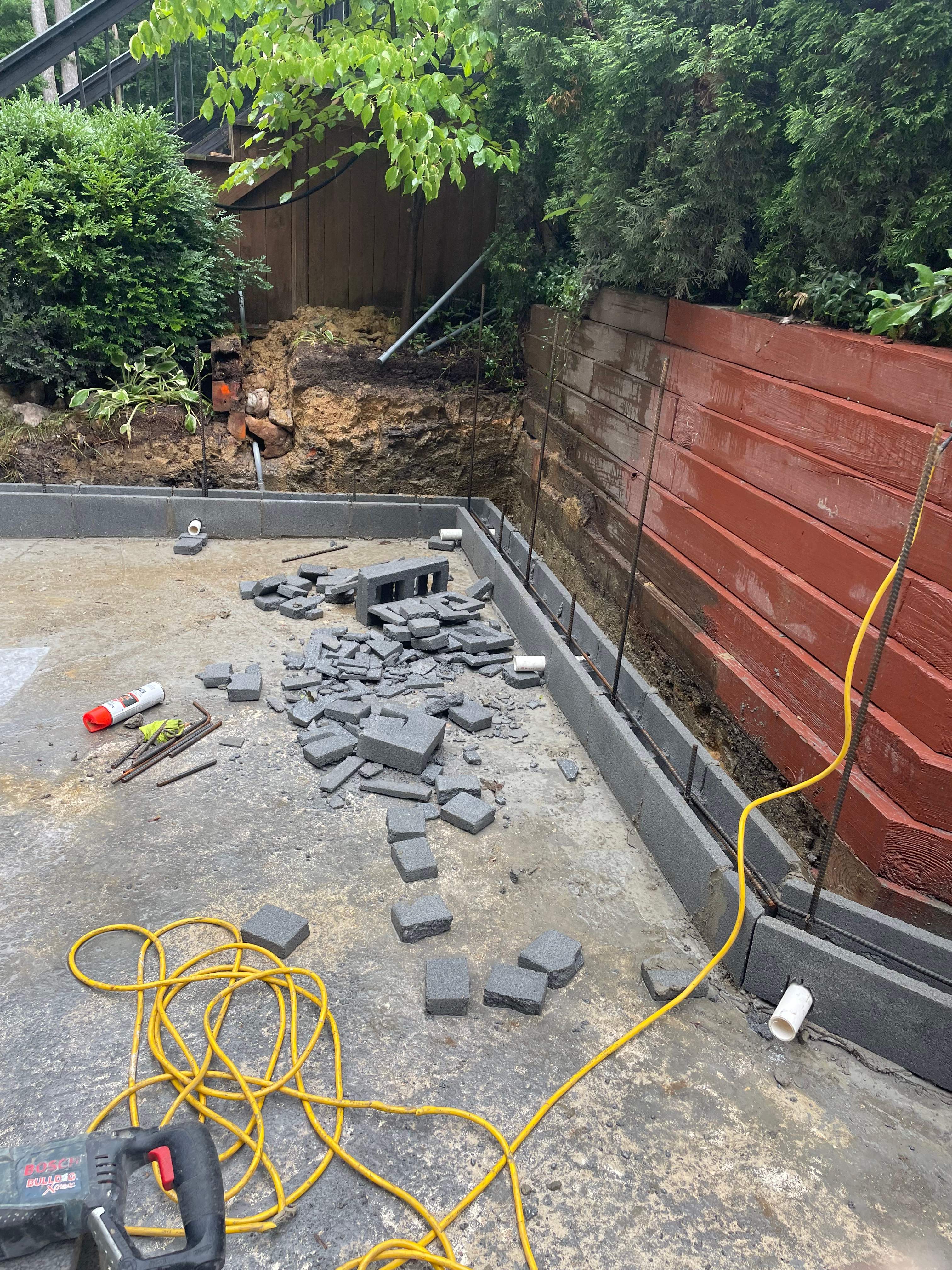 Pool Surround remodel with retaining walls, new waterfall and water slide by Fairfax Contractors, LLC