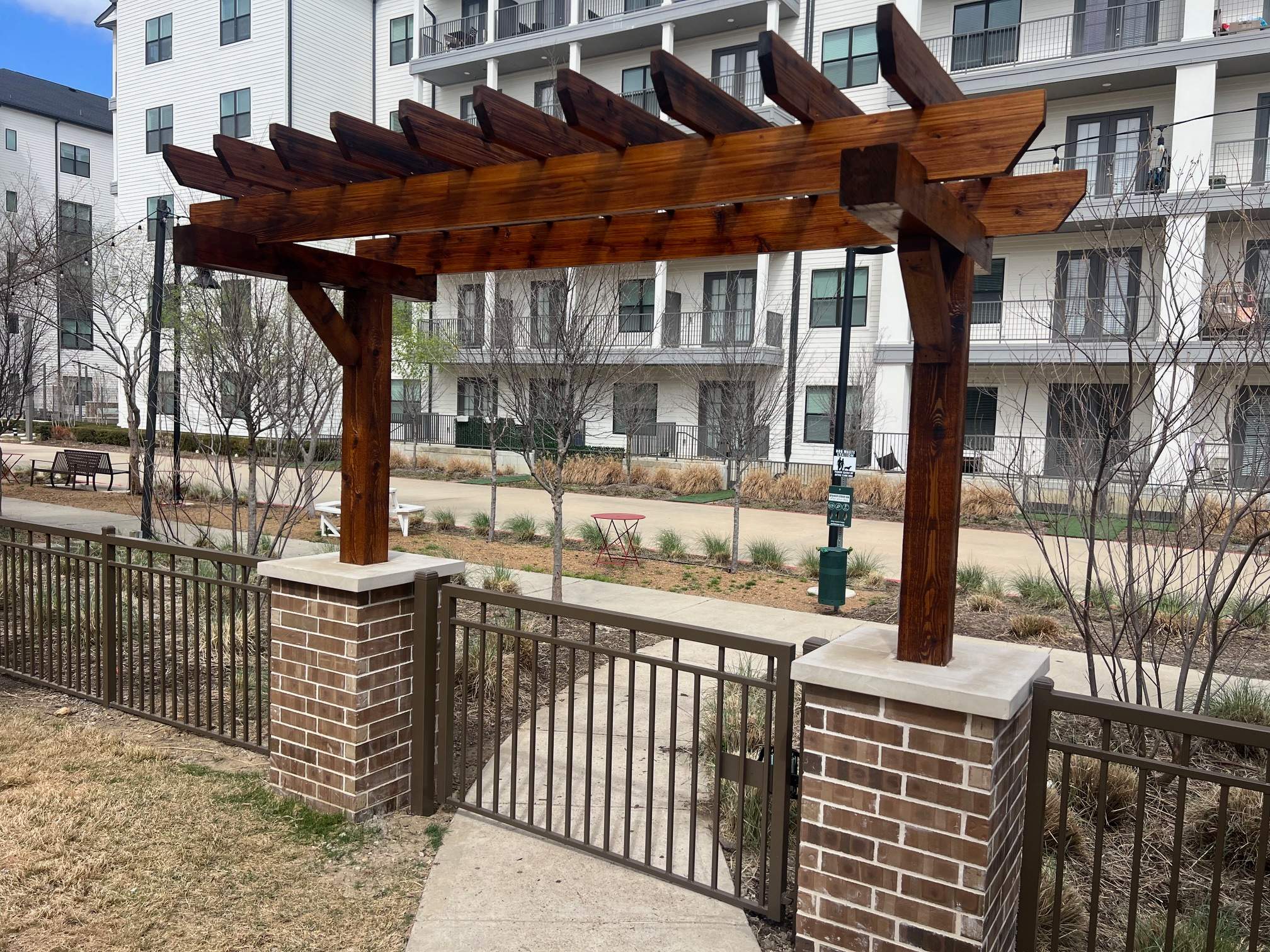 Arbor with Wrought Iron Fencing by 3:16 Roofing and Construction