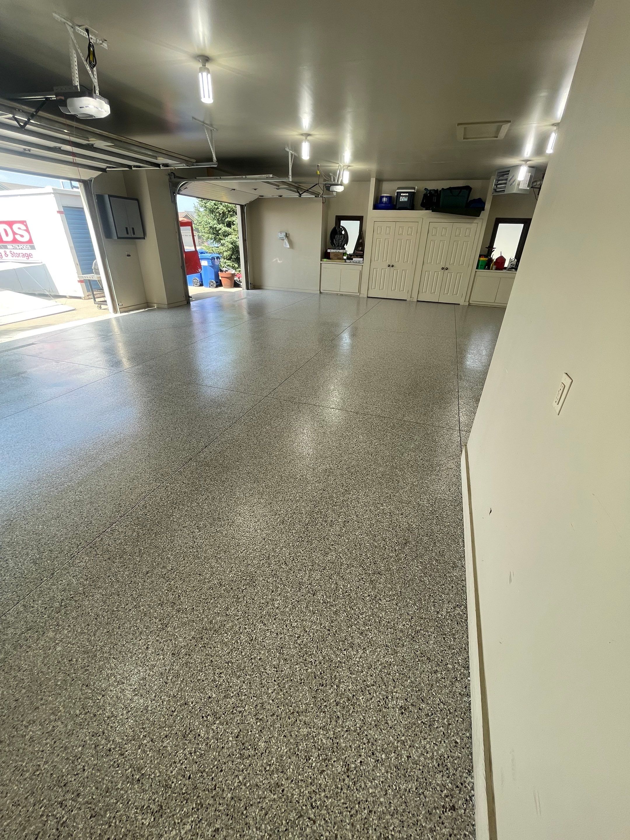 Coyote Flake Garage Floor Coating in Sioux Falls with Trench Drain by Select Painting, Coatings & Garage Cabinets