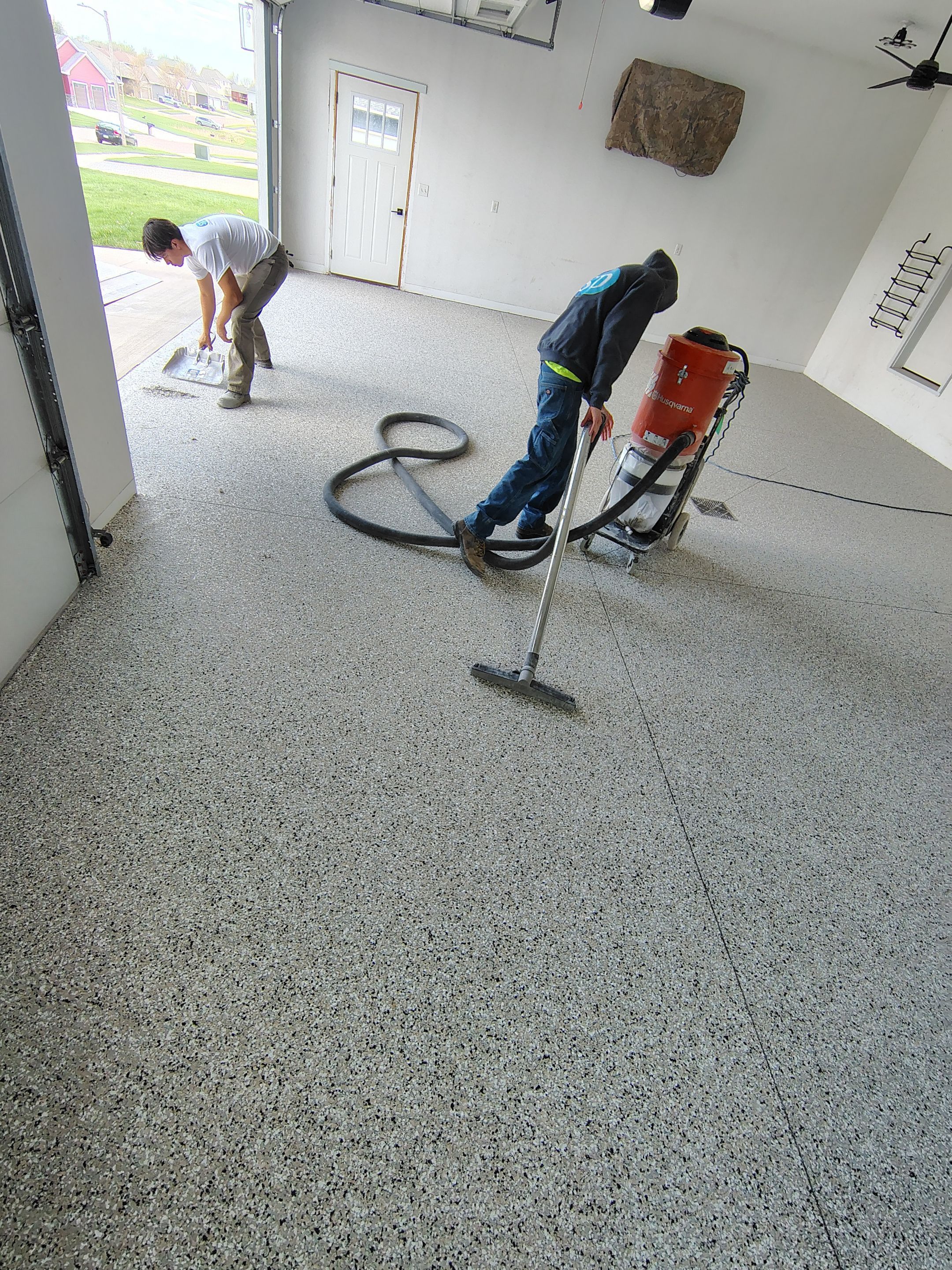 Speckled Polyaspartic Garage Floor Coating Installation in Dell Rapids by Select Painting, Coatings & Garage Cabinets