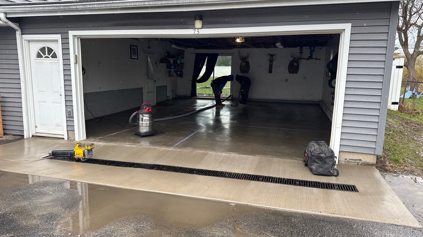 Concrete garage floor replacement with a broom finished apron and drain by NG Masonry & Construction LLC