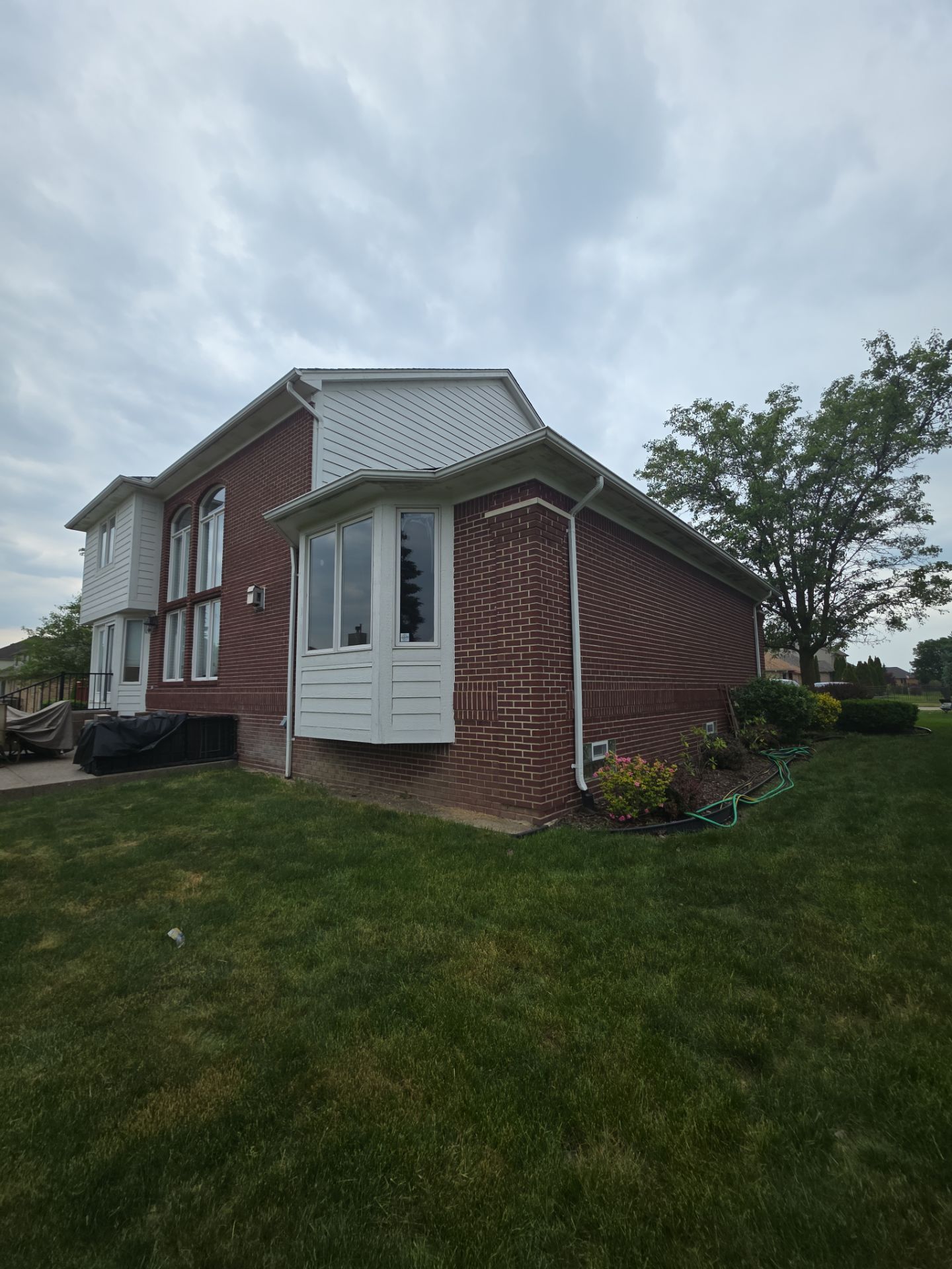 Siding and Trim Repair and Exterior Painting for a Macomb Brick Residence by Top Shelf Painter