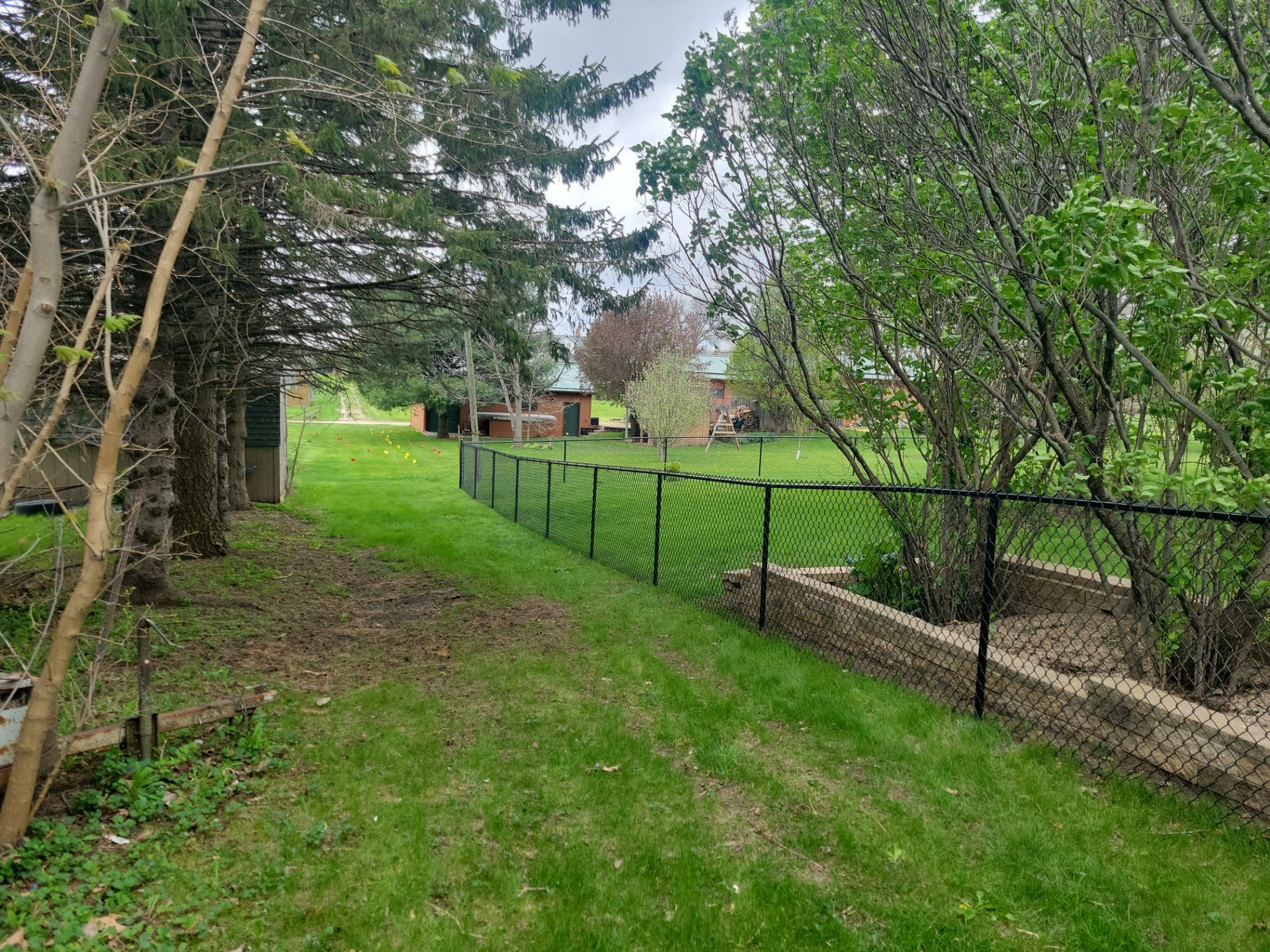 Residential Black Vinyl-Coated Chain Link Perimeter Fence in Garwin by Perfect Picket Fence and Stain