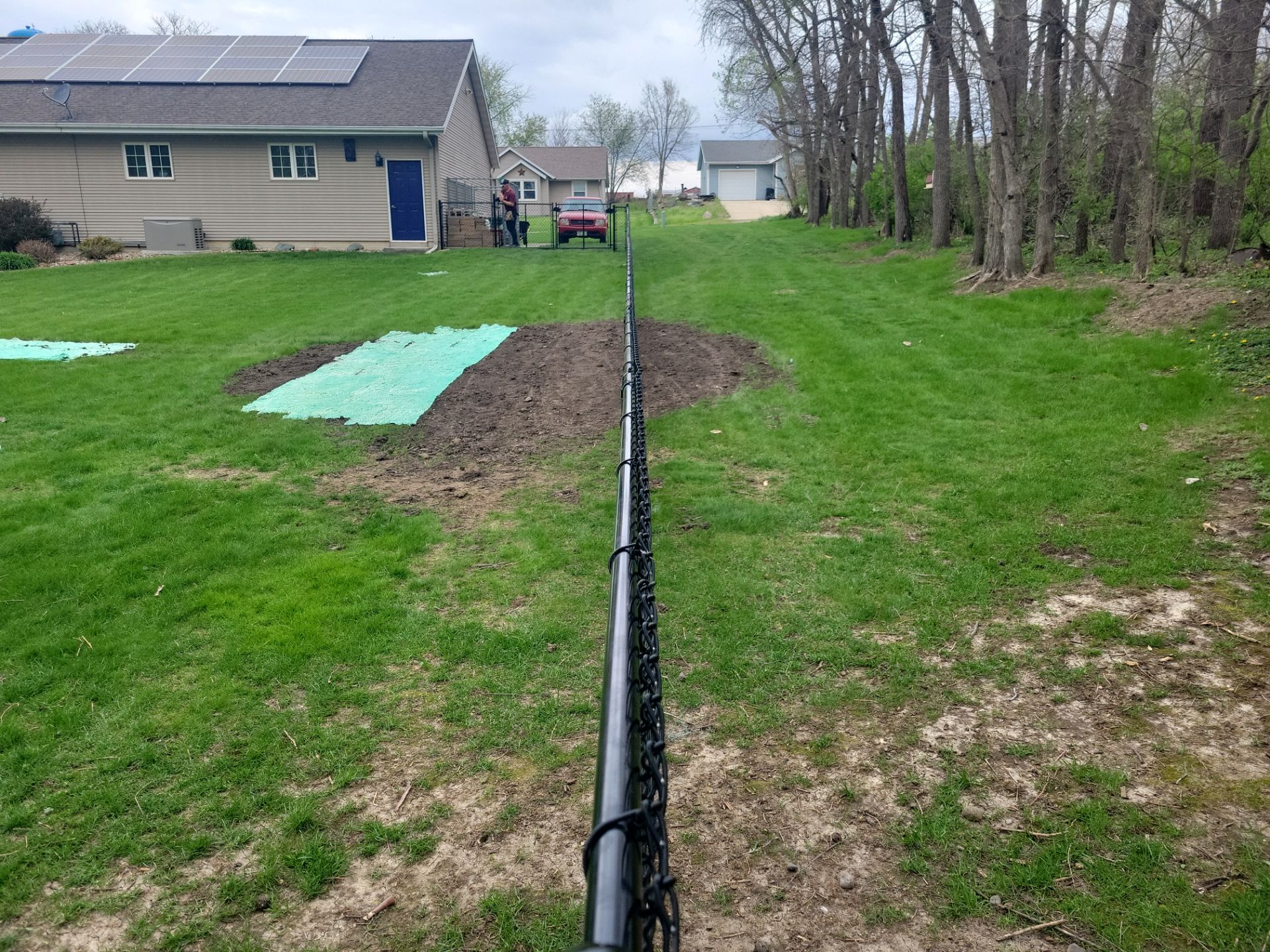 Residential Black Vinyl-Coated Chain Link Perimeter Fence in Garwin by Perfect Picket Fence and Stain