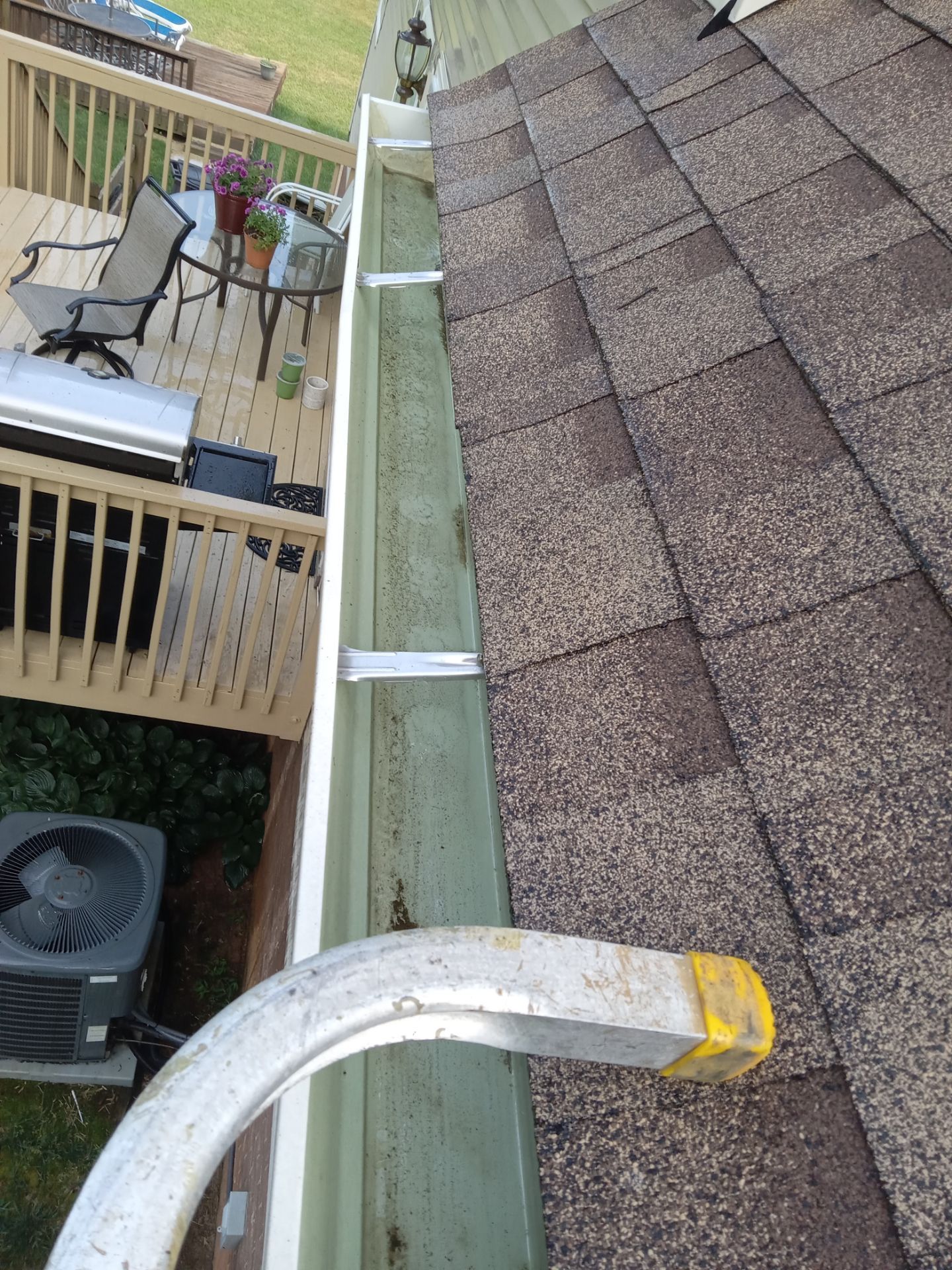 pressure washing algae and debris off a residential gutter and downspout