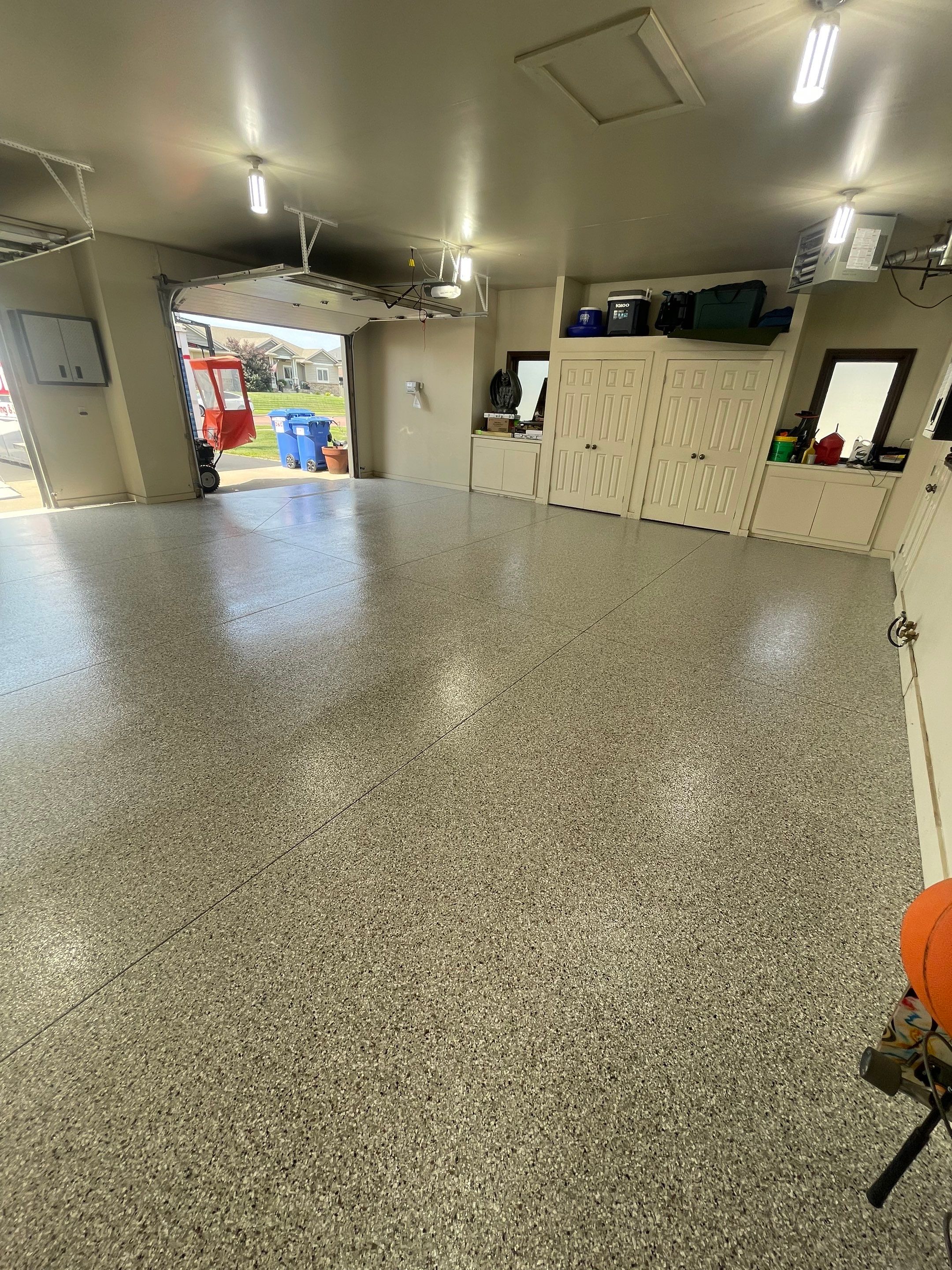 Coyote Flake Garage Floor Coating in Sioux Falls with Trench Drain by Select Painting, Coatings & Garage Cabinets