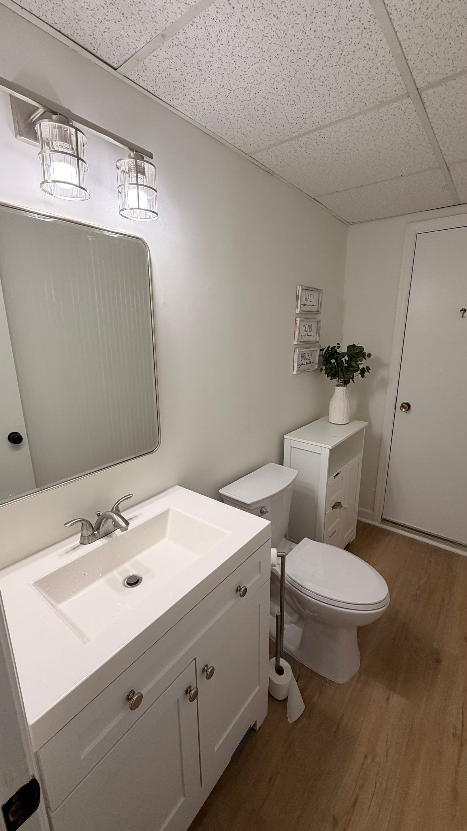 Basement Remodeling with Wood-Look Flooring and Custom Wainscoting in Dunwoody by Swift Home Renovations