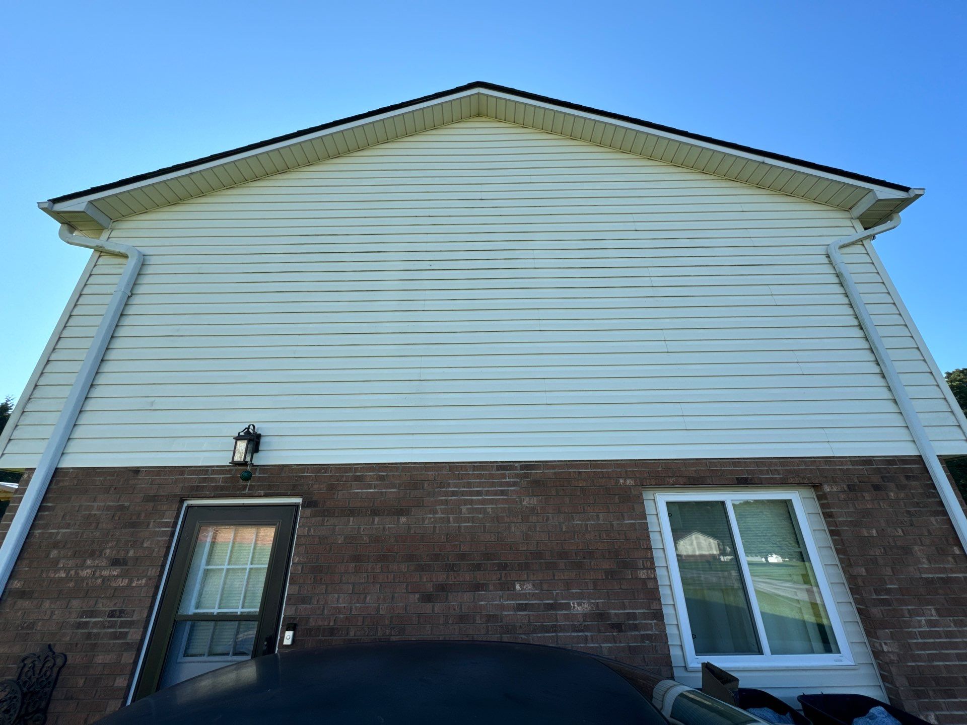 the service shown is cleaning the exterior of a house specifically focusing on the siding and brick surfaces for better appearance