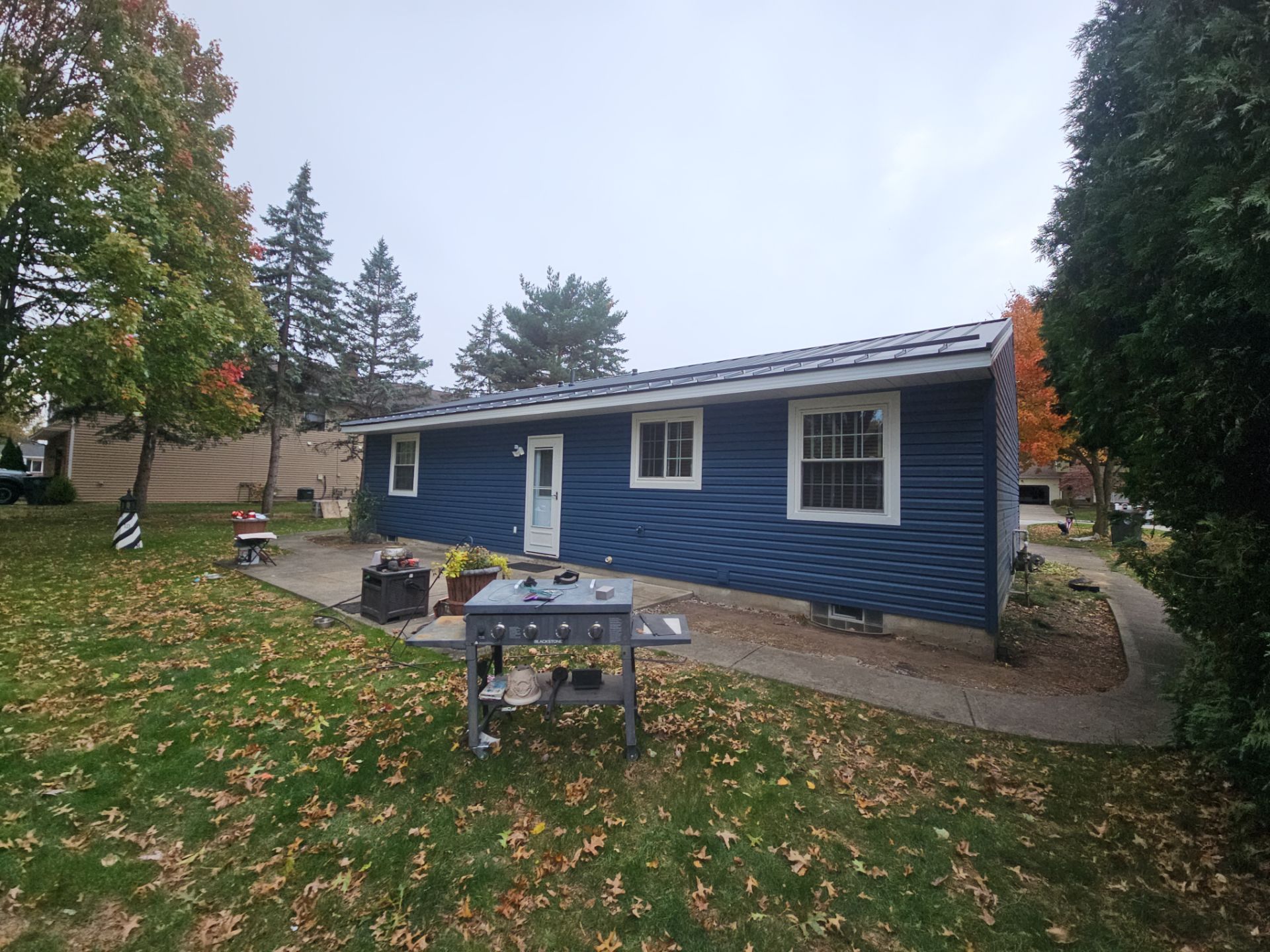 Wadsworth Exterior Transformation Featuring Blue Vertical Siding and Metal Roofing by Cornerstone Roofing And Siding
