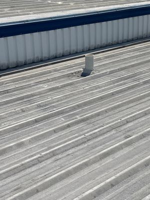 Close up of corrugated metal roof with vent pipe