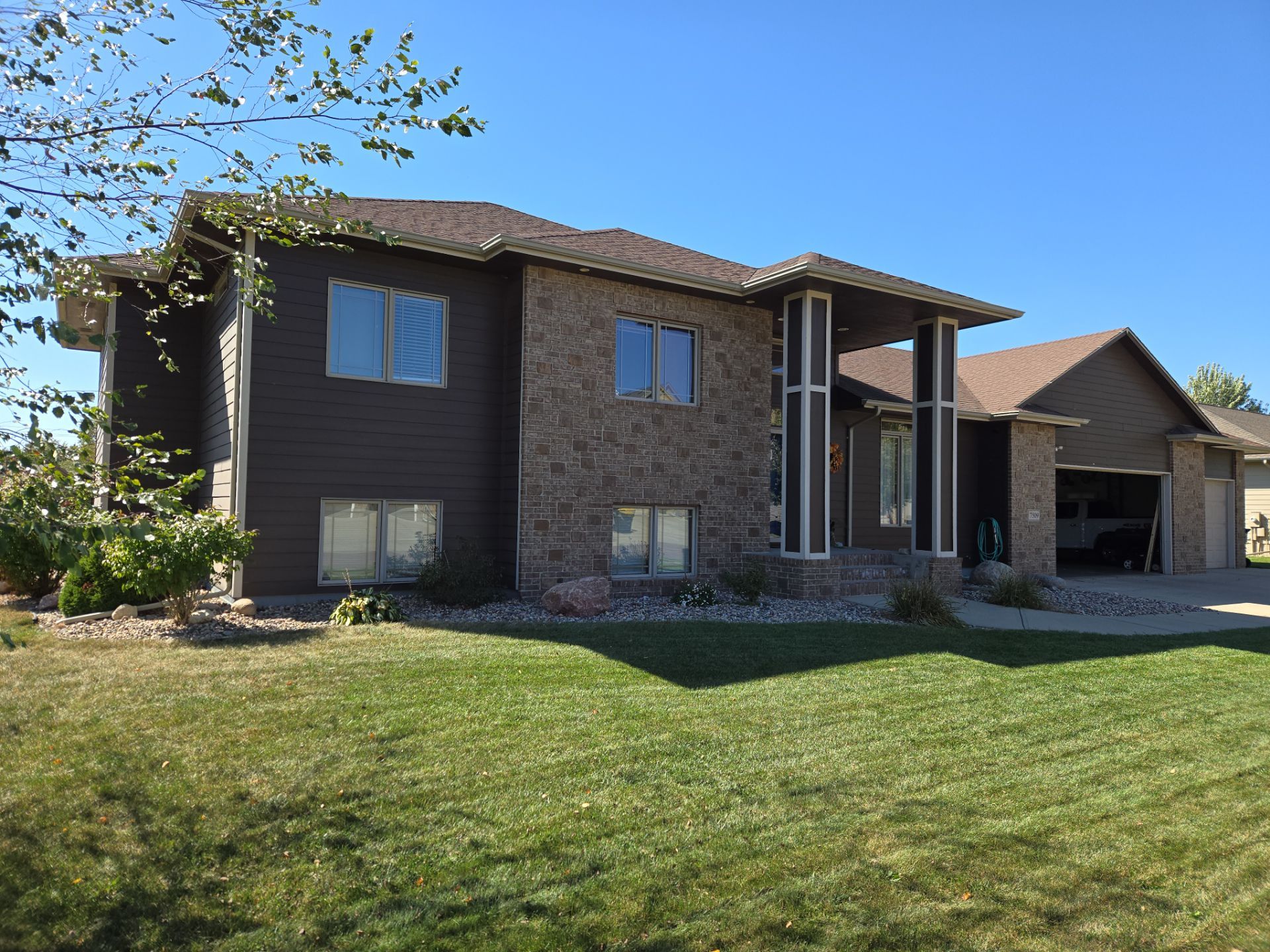 Dark Blue Exterior Home Painting and Siding Refresh in Sioux Falls by Select Painting, Coatings & Garage Cabinets