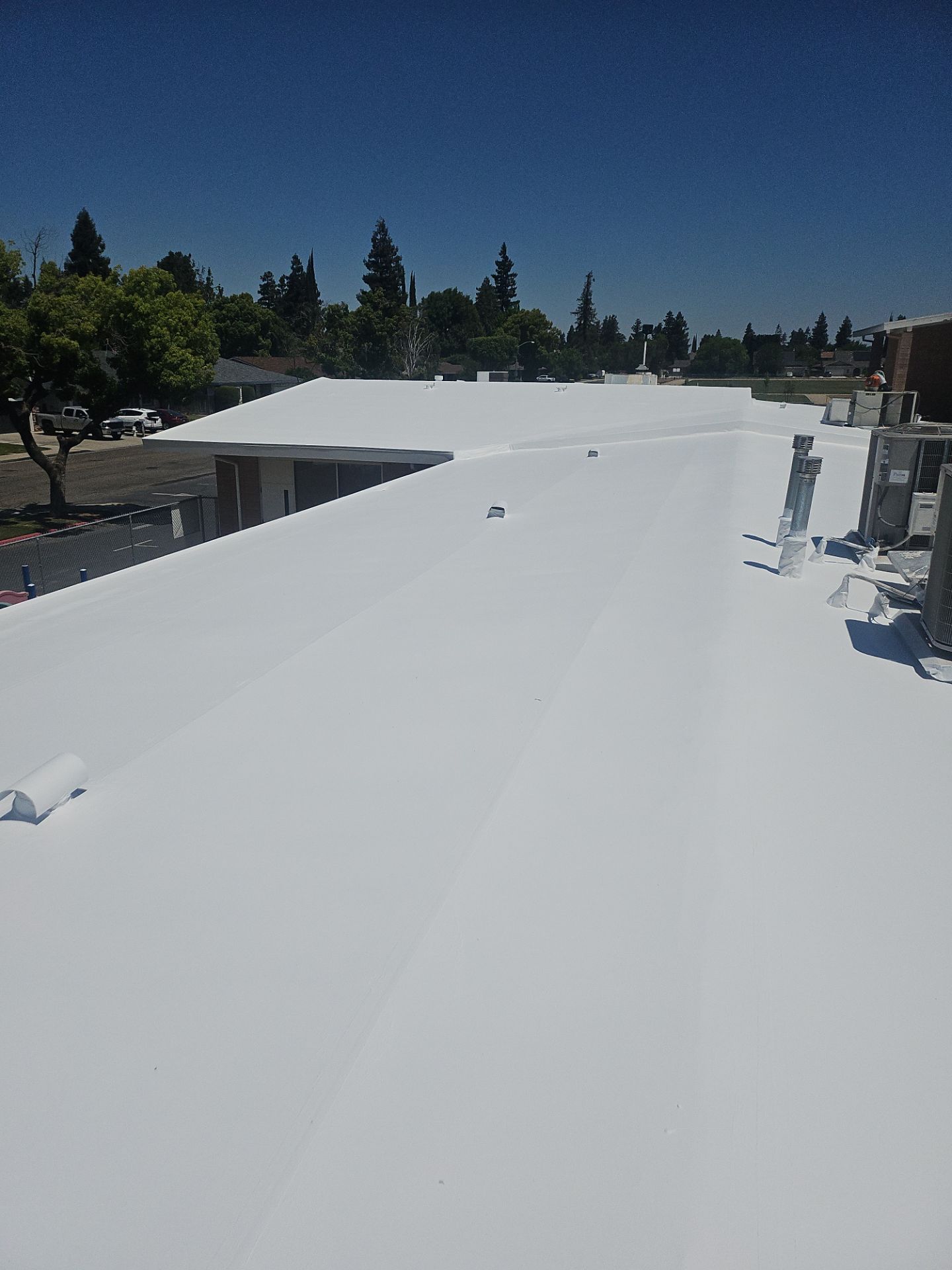 Single-ply restoration system using Benchmark/PUMA XL coatings over TPO single-ply roofing by Straight Edge Roofing Inc