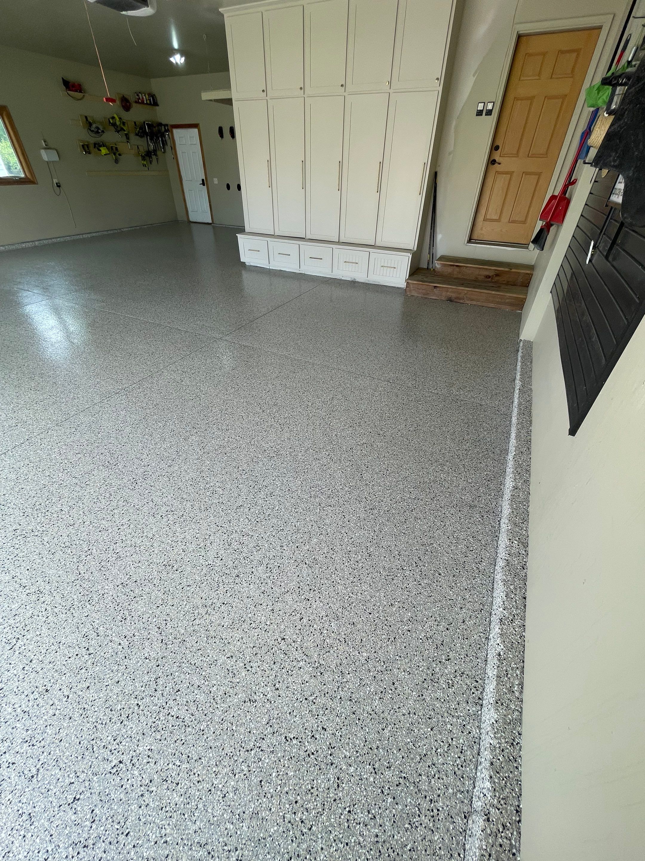 Cabin FEver Flake Garage Floor Coating Installation in Sioux Falls by Select Painting, Coatings & Garage Cabinets