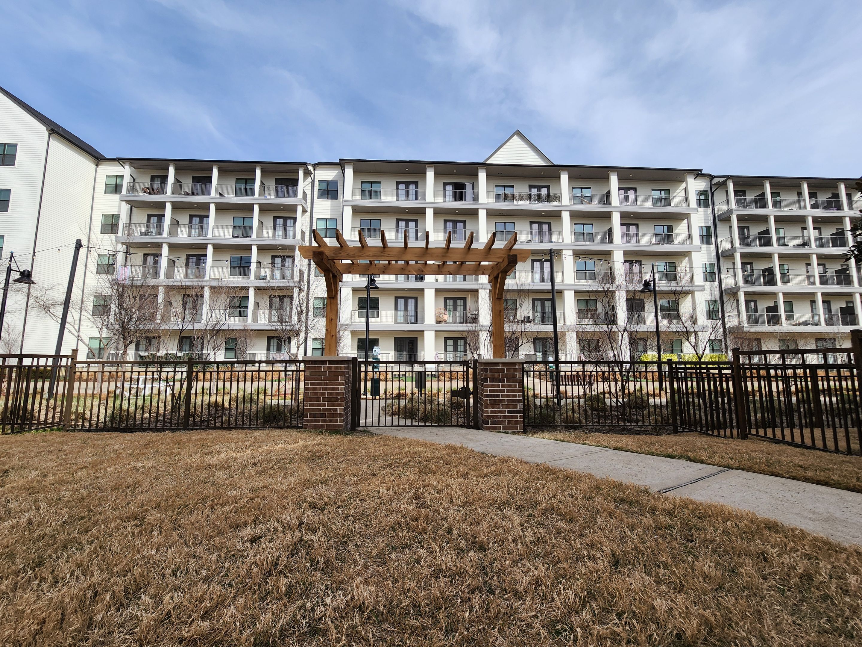 Arbor with Wrought Iron Fencing by 3:16 Roofing and Construction