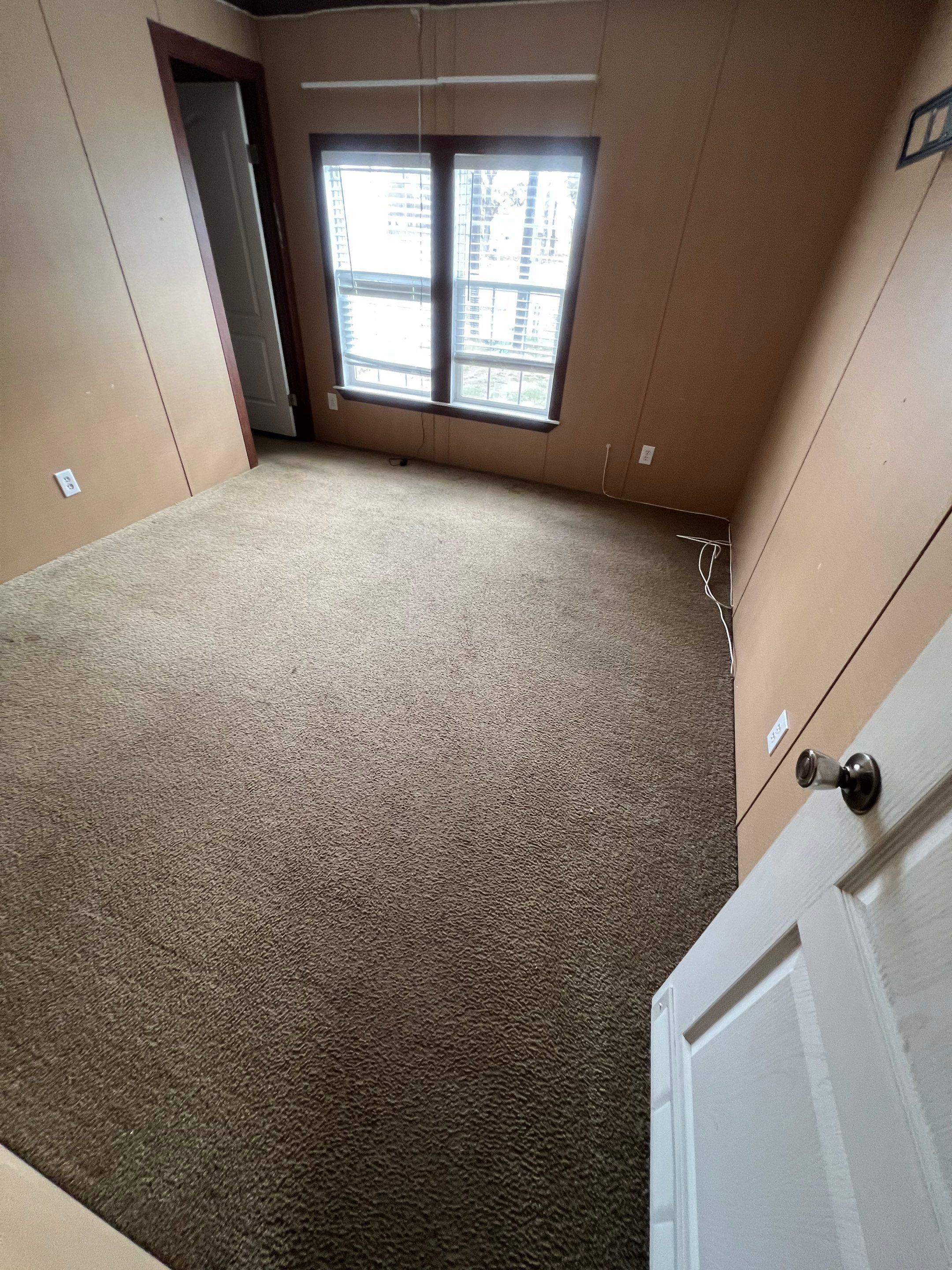 the service being done is carpet cleaning for the room shown with light brown carpet and minimal furnishings