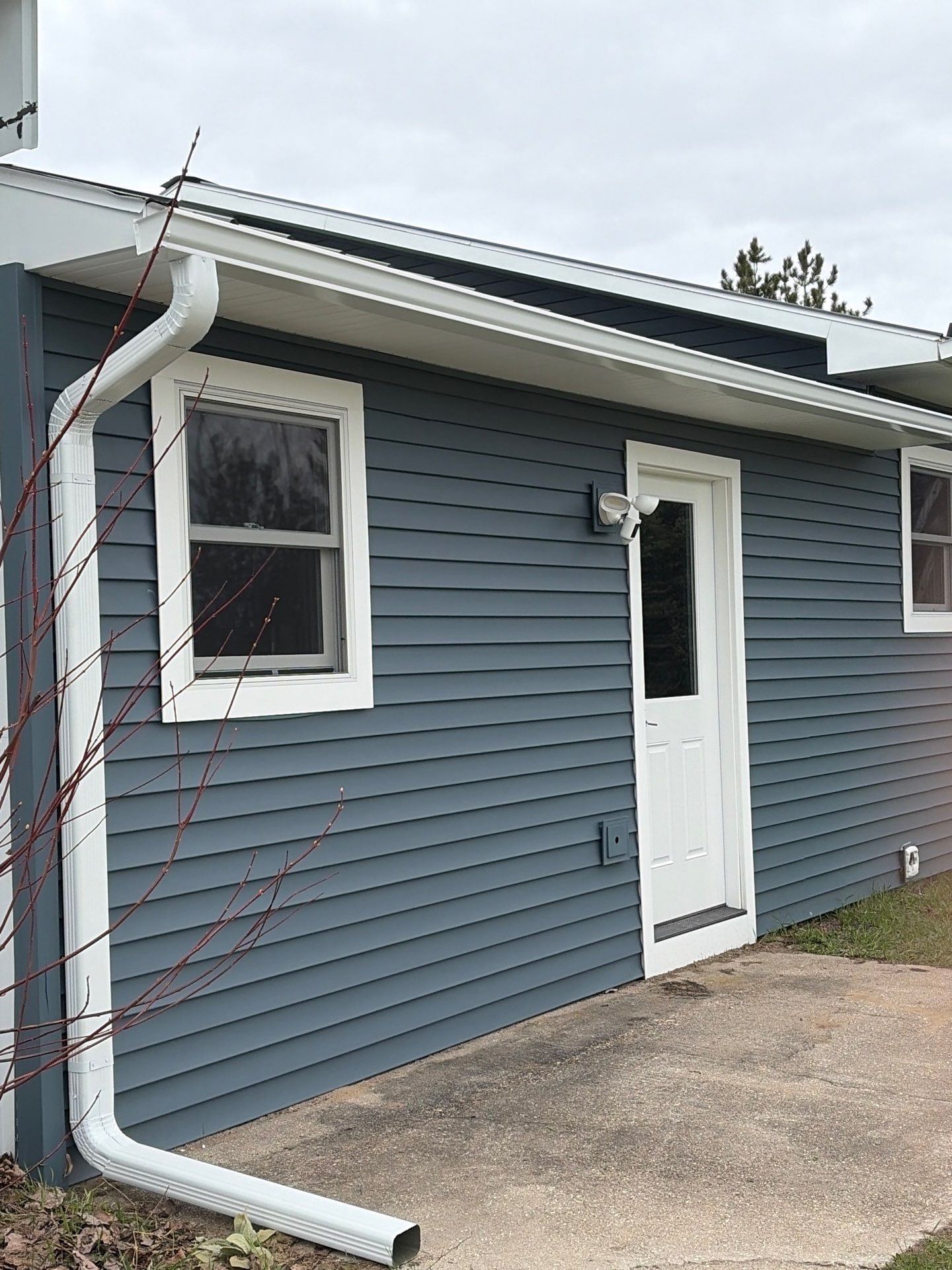 White Gutter and Downspout Installation for Boyne Falls Residential Property by Rainbow Seamless Systems