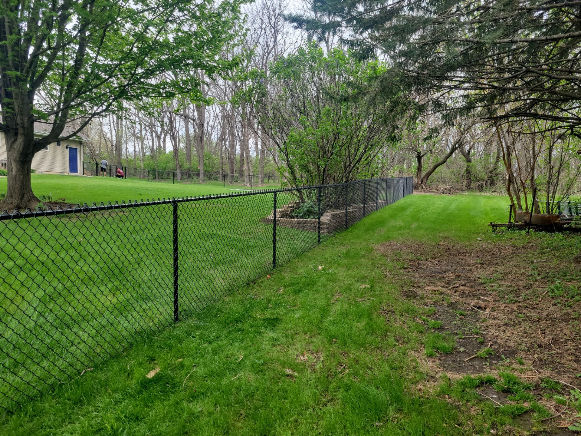 Residential Black Vinyl-Coated Chain Link Perimeter Fence in Garwin by Perfect Picket Fence and Stain