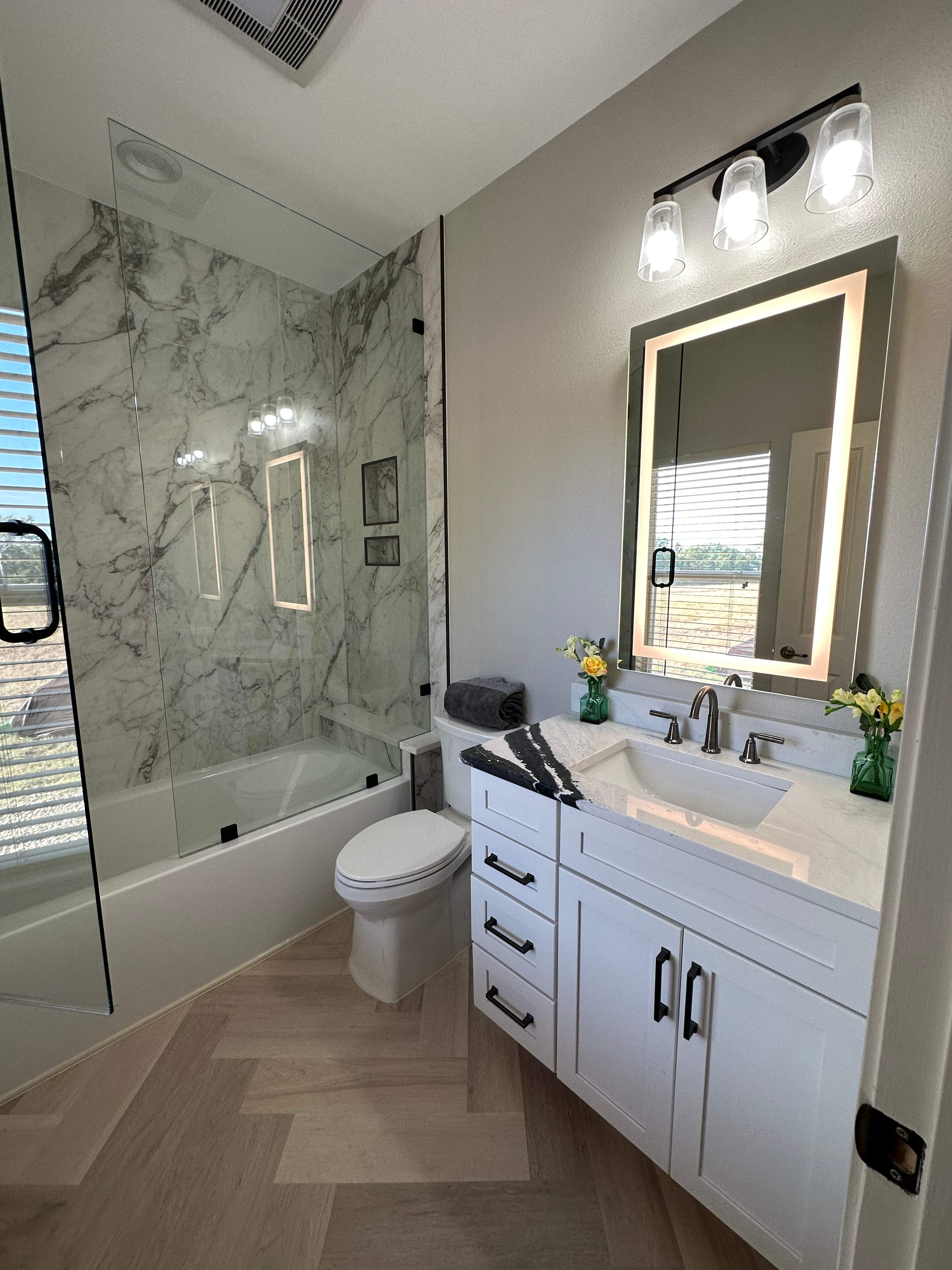 Boerne Guest Bathroom Remodel with Marble Tub Surround & Herringbone Flooring by Legacy Bath and Kitchen