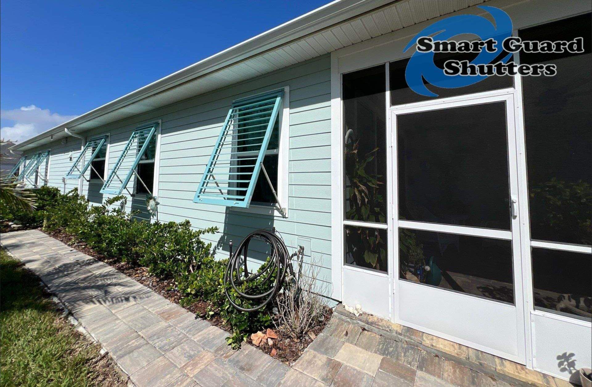 Impact Bahama Shutters in Pastel Turquoise by Smart Guard Shutters