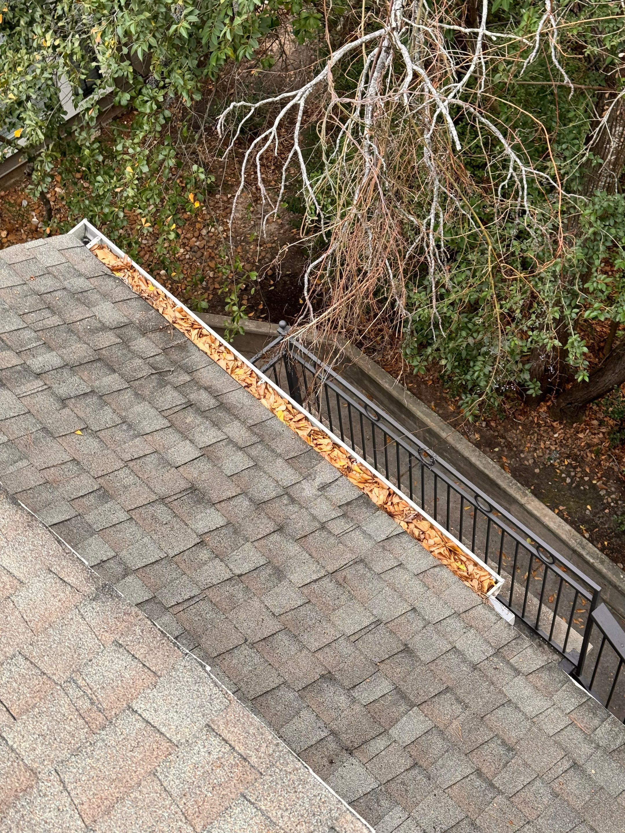 Commercial gutter cleaning The Woodlands & Conroe before photo with filled gutters