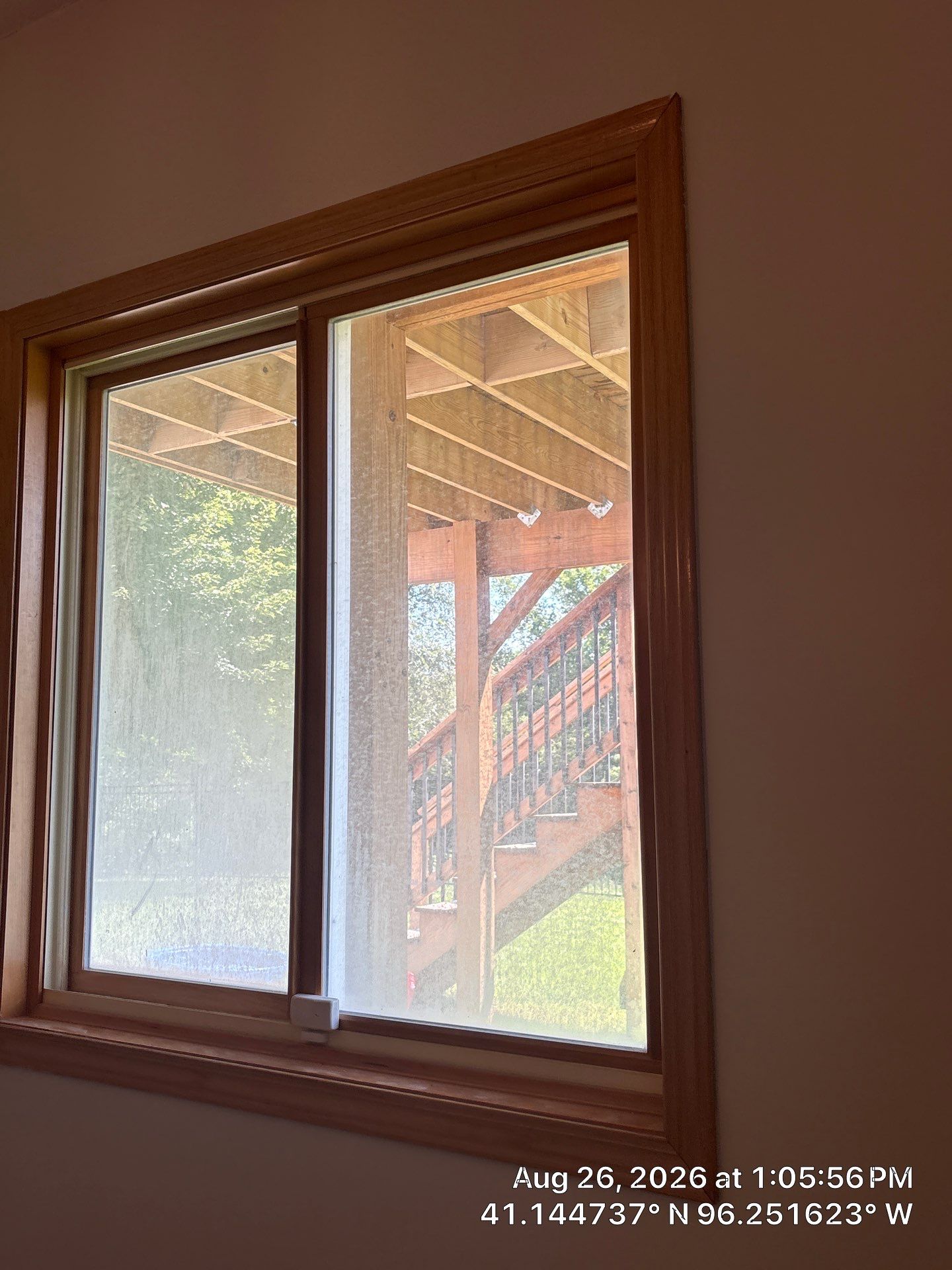 Residential Sliding Window Installation With Natural Wood Trim by CompanyCam Sales Demo