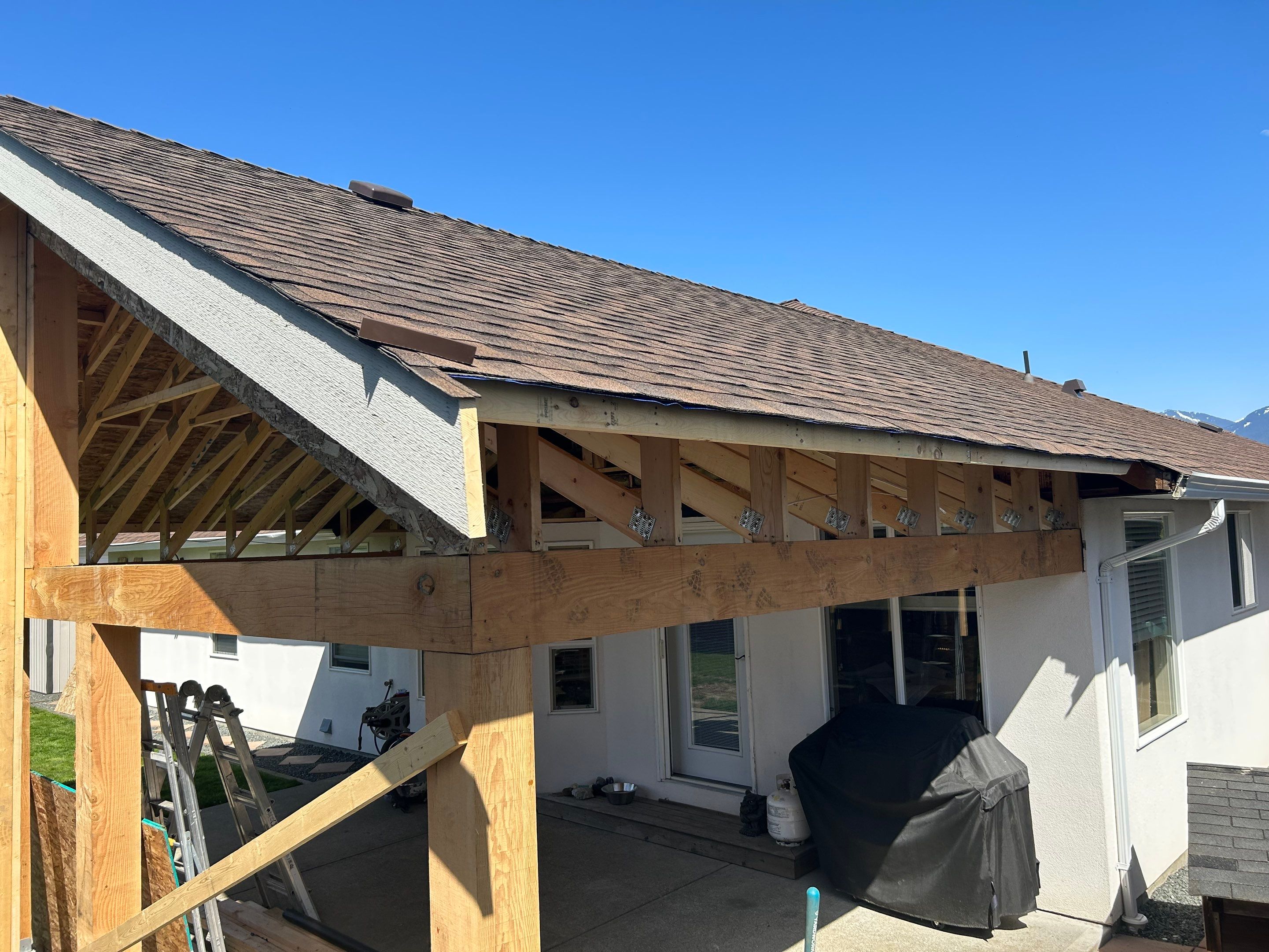 Residential patio roof extension with IKO Dual Brown shingles by Top Notch Roofing Inc
