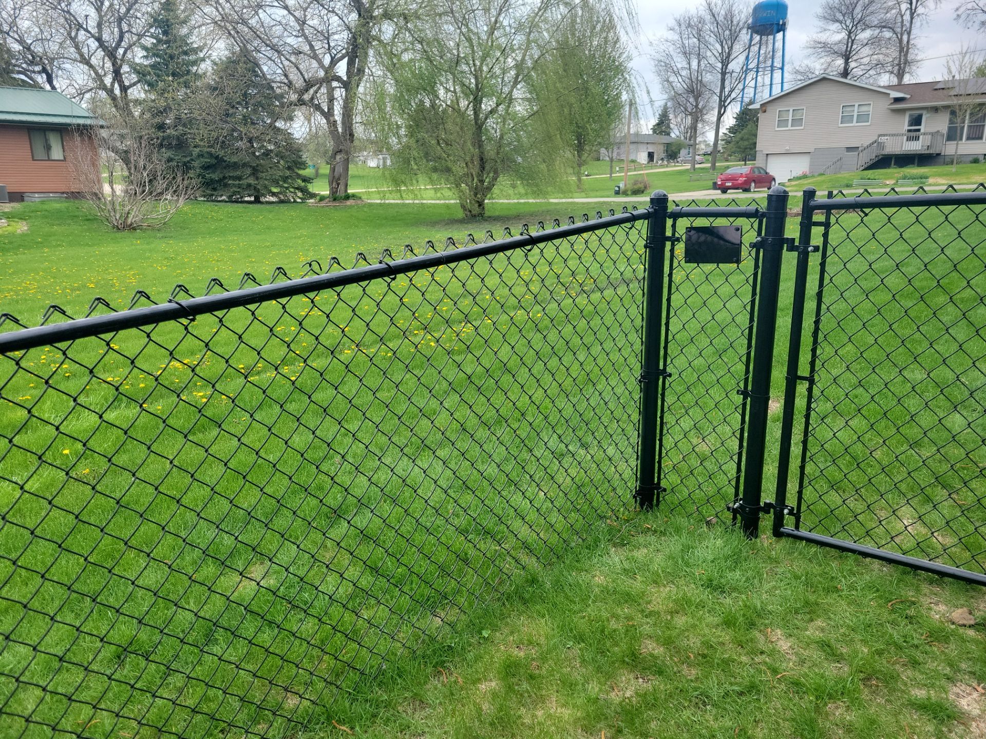 Residential Black Vinyl-Coated Chain Link Perimeter Fence in Garwin by Perfect Picket Fence and Stain