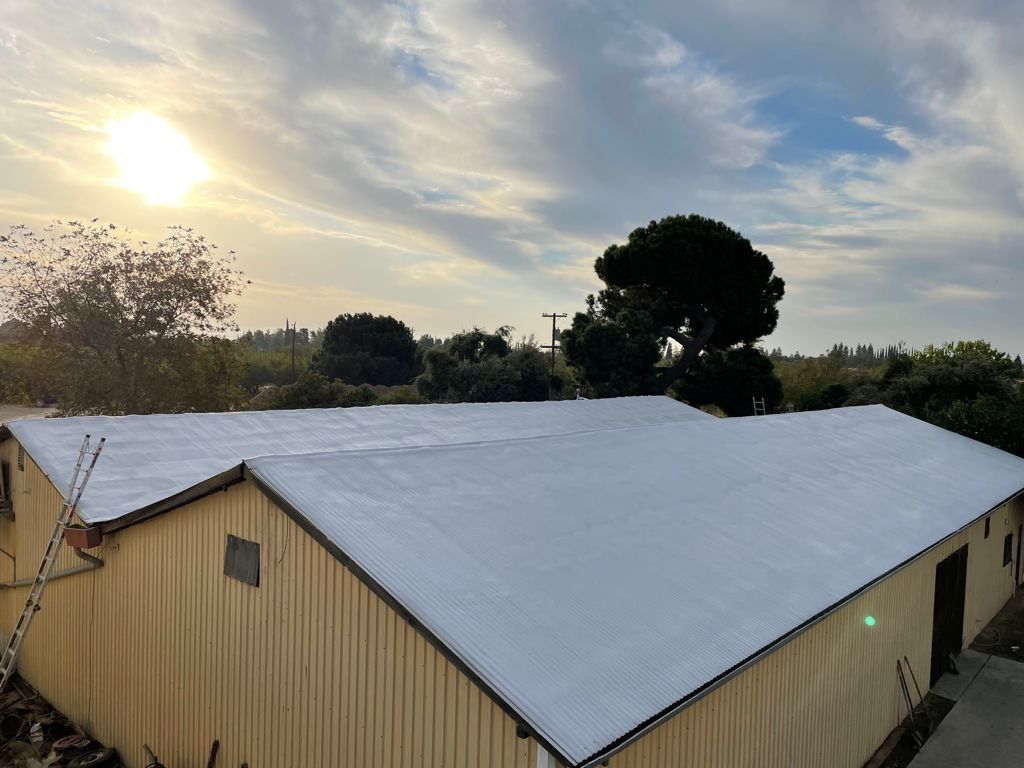 Metal roof sprayed with polyurethane spray foam and coatings by Straight Edge Roofing Inc