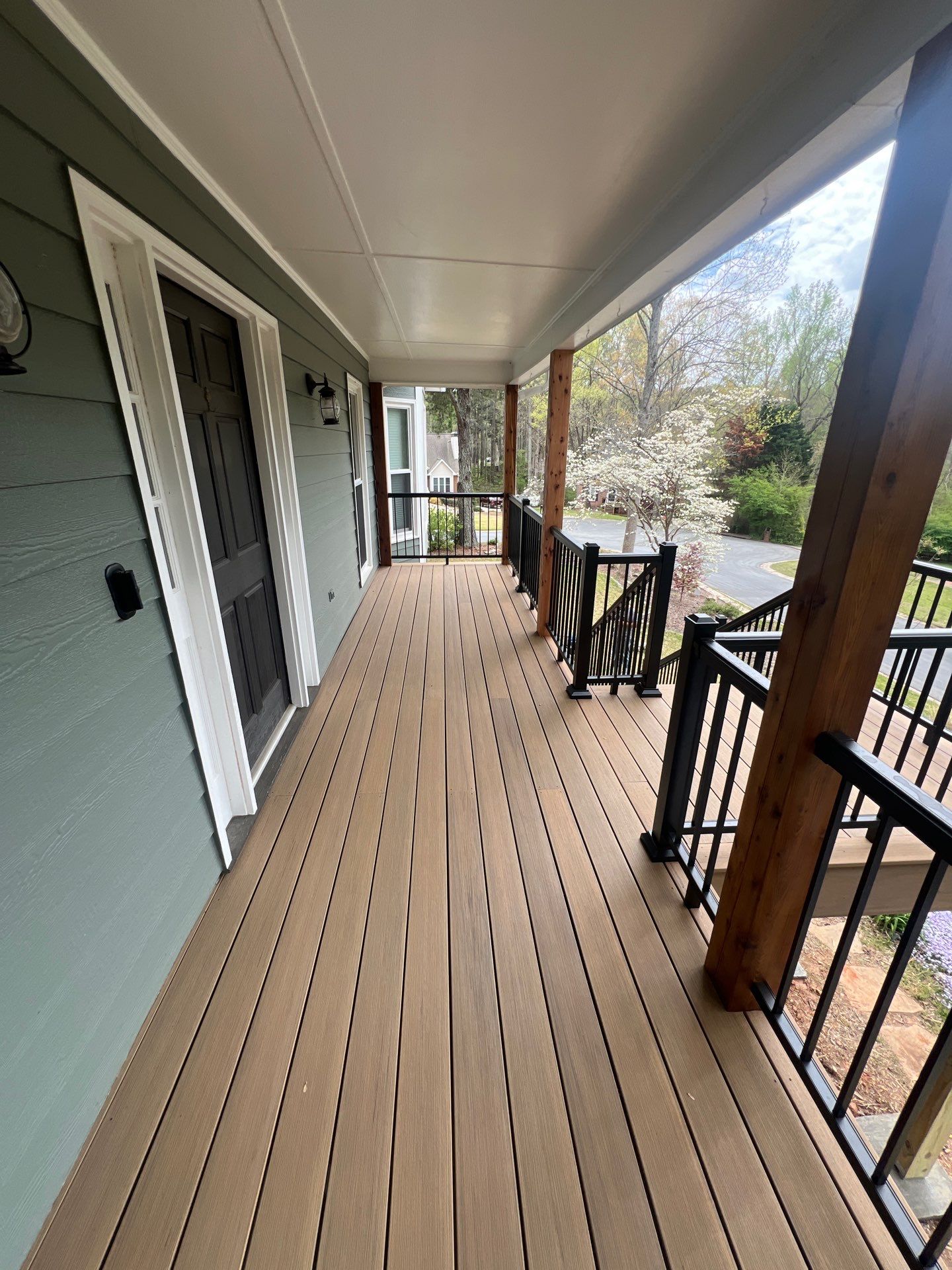 Composite Deck and Porch Renovation With Black Metal Railings by Swift Home Renovations 