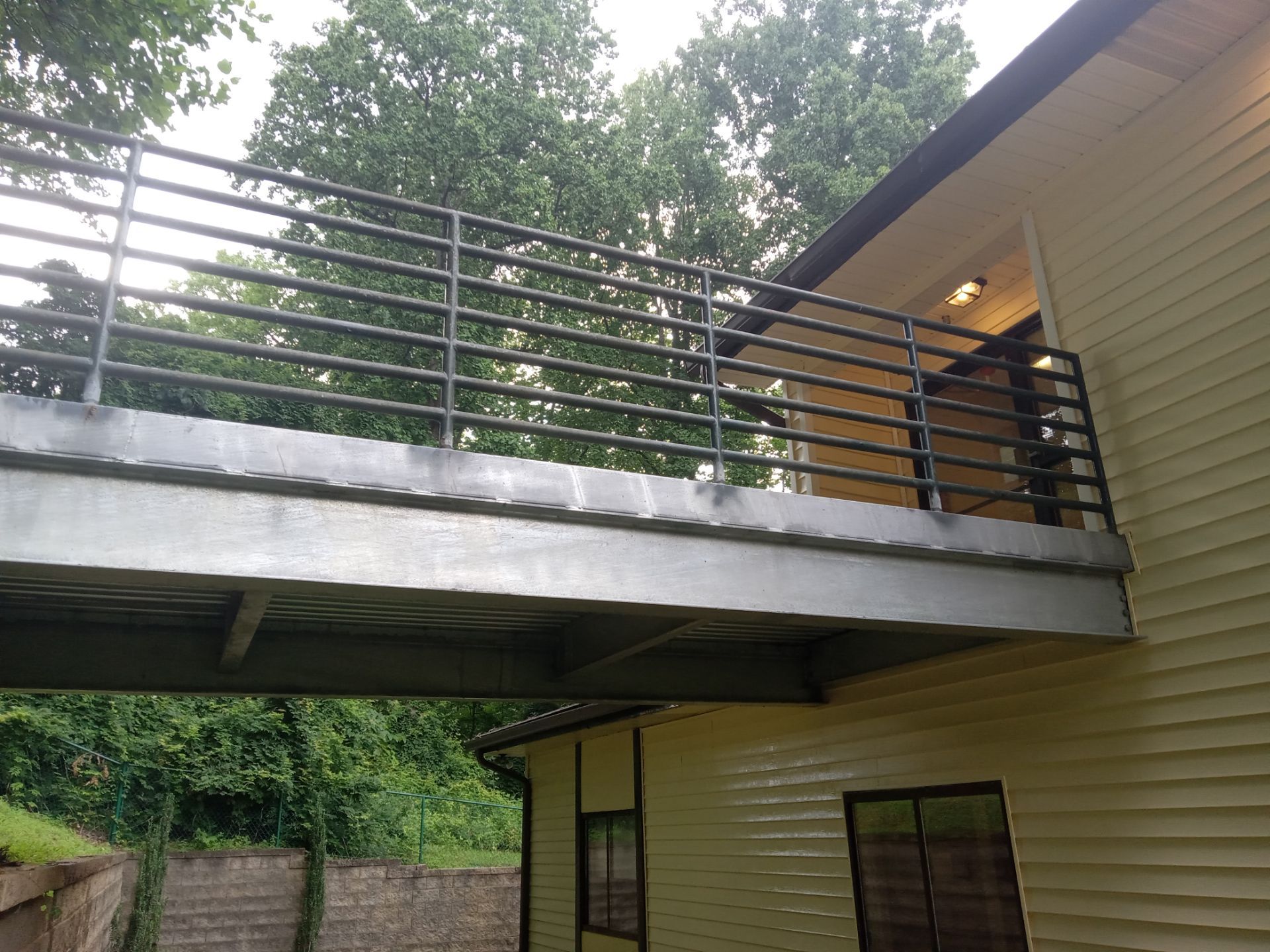 pressure washing exterior siding and metal balcony railings for cleaning dirt and grime buildup