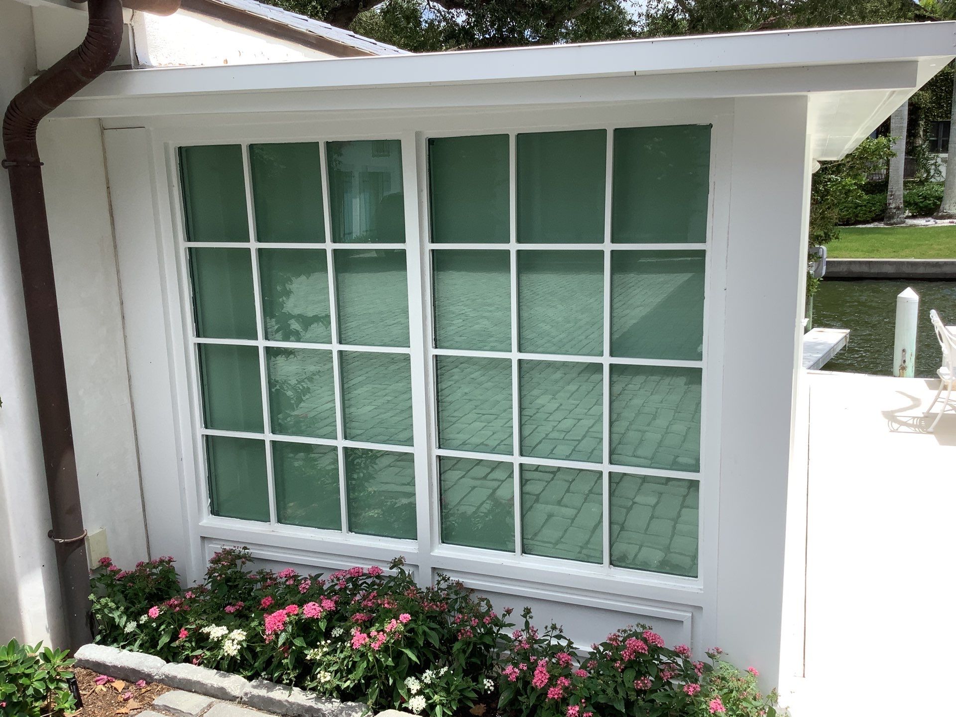 Seamless aluminum gutter installation in Sarasota, FL using 3x4 elbow downspouts combined with round downspouts by Gutter Professors