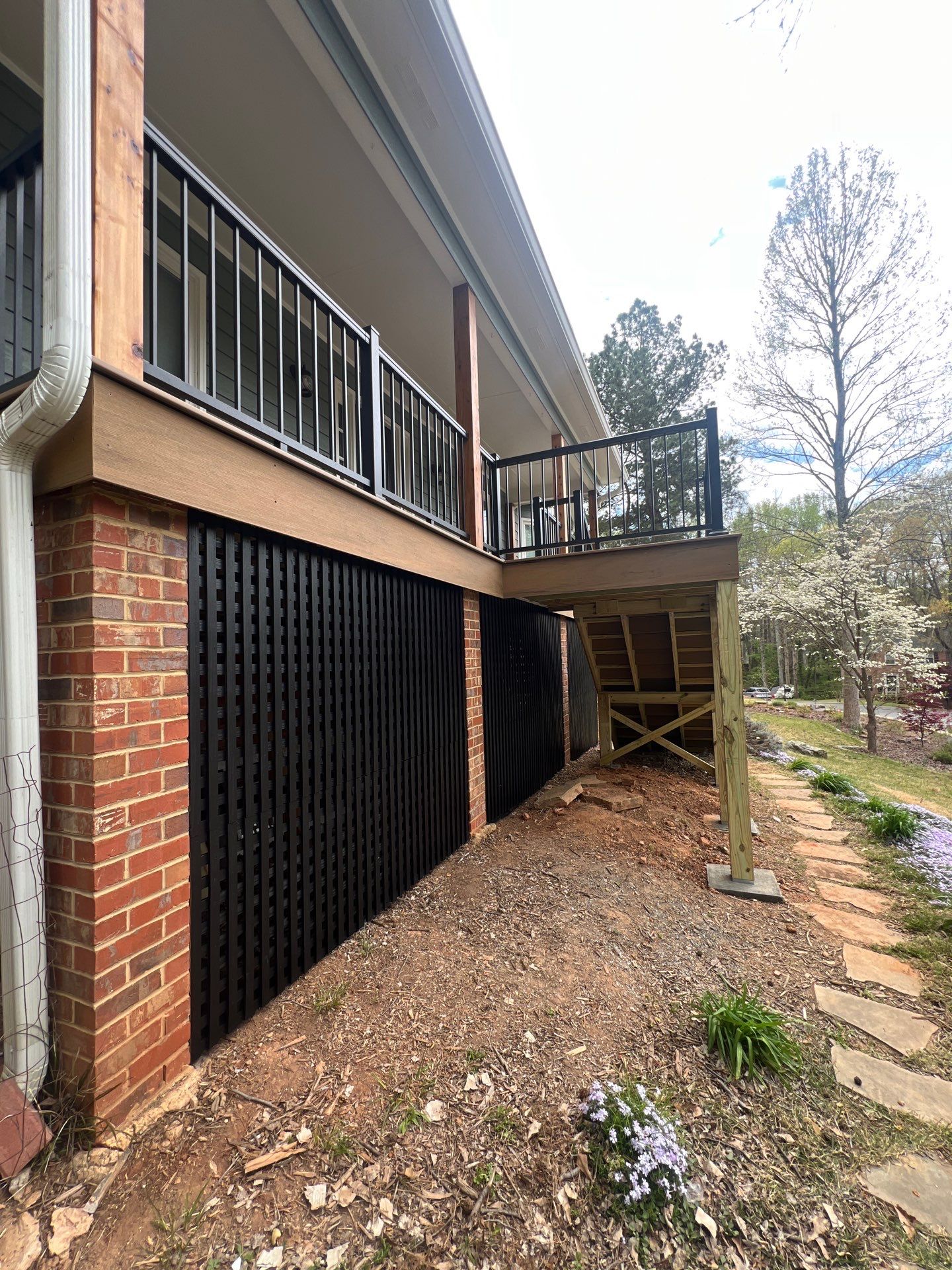 Composite Deck and Porch Renovation With Black Metal Railings by Swift Home Renovations 