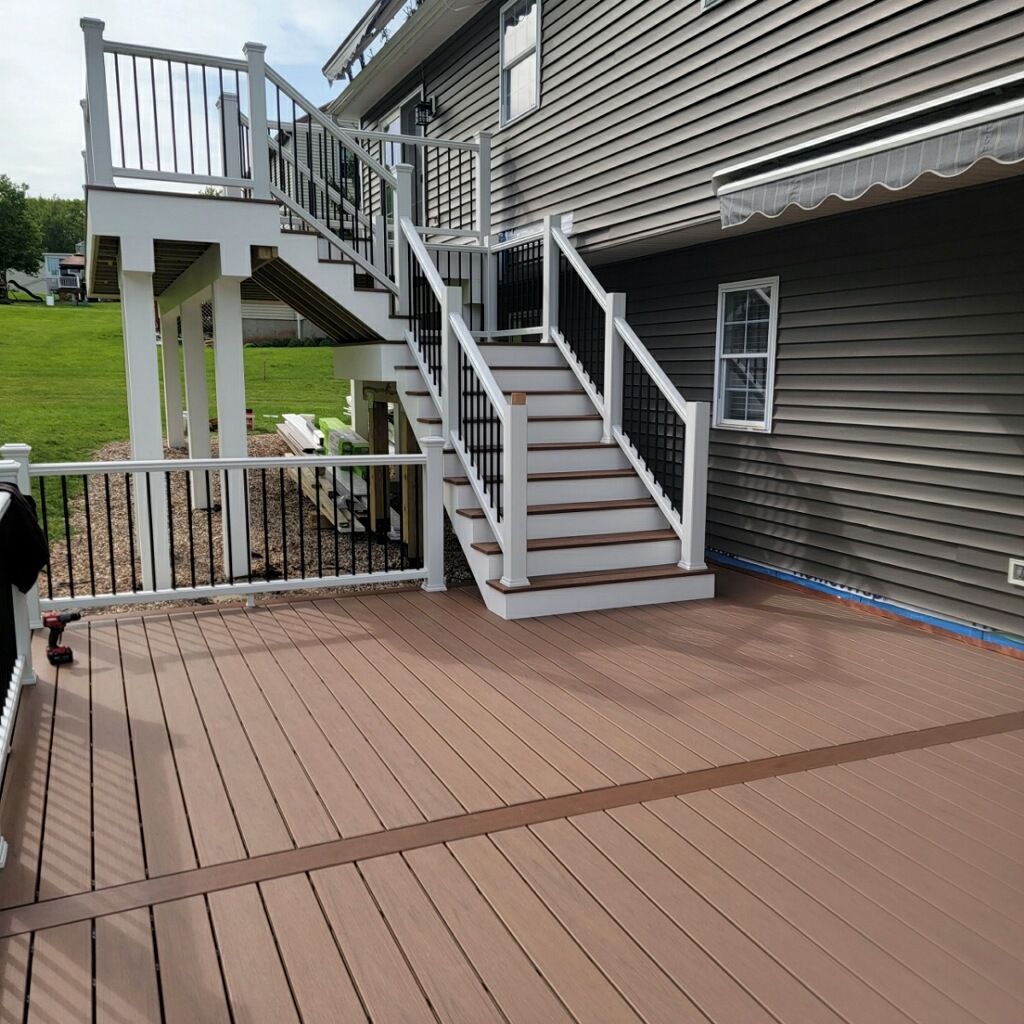 New Two Tier deck using Trex Hatteras boards and White Composite railings. by DiGiorgi Roofing and Siding Inc