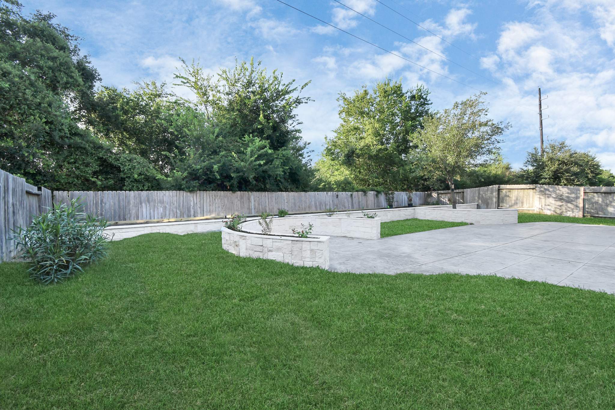 Major Transformation Project: Retaining Wall, Patio, and Drainage for Mr. & Mrs. Veerman! 🤩🛠️ We recently completed a comprehensive, custom project for Mr. & Mrs. Veerman that was all about structure, stability, and stunning outdoor design! This was a multi-phased project requiring the expertise of our Master Handcrafted Team.  Phase 1: Foundation and Water Management A successful outdoor space starts beneath the surface. We focused heavily on preparation and protection:  Demolition & Grading: We professionally removed and disposed of old dirt to achieve a level surface, ensuring the entire area was leveled and graded to enhance both appearance and functionality.  Comprehensive Drainage System: To prevent water issues and protect the new construction, we installed a complete system, connecting existing downspout gutters to channel drainage and strategically placed catch basins around the patio area.  Robust Concrete Foundation: Expert framing led to the pouring of a 4-inch deep, high PSI concrete slab to create a robust and lasting foundation for the entire retaining wall area.  Phase 2: Handcrafted Structure and Style This phase brought in our masonry and carpentry artisans to build the defining elements of the new space:  Custom Retaining Wall: Our master handcrafted team built a stunning, structural retaining wall. This involved careful framing, precise concrete work, and meticulous masonry construction with vertical supports every 3 feet for maximum stability.  Client Involvement: Mr. & Mrs. Veerman played a key role in selecting the retainer wall fascia and stone materials, ensuring the final look perfectly matched their vision.  Stamped Concrete Patio: We installed a beautiful stamped concrete patio. This decorative concrete work involved imprinting a pattern into the fresh concrete, giving them the high-end look of stone or brick with the durability of concrete.  Walk Add-On: Extended the stamped concrete to include a new, seamless walk area.  (Optional) Custom Garden Box: Constructed durable, raised garden boxes using 2"x12" boards and strong 4"x6" posts.  Phase 3: Landscaping and Finishing Touches The final details bring the entire project to life, focusing on irrigation and planting:  Sprinkler System Upgrade: To support their new landscaping, we upgraded their irrigation system by installing two new drip zones and a new control unit.  Flower Beds: Integrated new flower beds along the retaining wall and patio, ready for planting.  Decoration: Concluded the project with personalized decoration options to perfectly complement their beautiful, newly structured space.  Thinking About a Multi-Layered Outdoor Project? This project demonstrates our ability to seamlessly handle complex jobs—from heavy-duty drainage and structural construction to decorative finishes and irrigation.  The proposed timeline for this extensive project was 10 to 15 working days!  ❓ Do you have a sloping yard or drainage issues that could be solved with a functional and beautiful retaining wall? Tell us your challenge! 👇  💡 We specialize in bringing intricate outdoor visions to life! If you're looking for a team with master craftsmen for your next patio, retaining wall, or full landscape overhaul, let's talk. by Texas Urban Elements