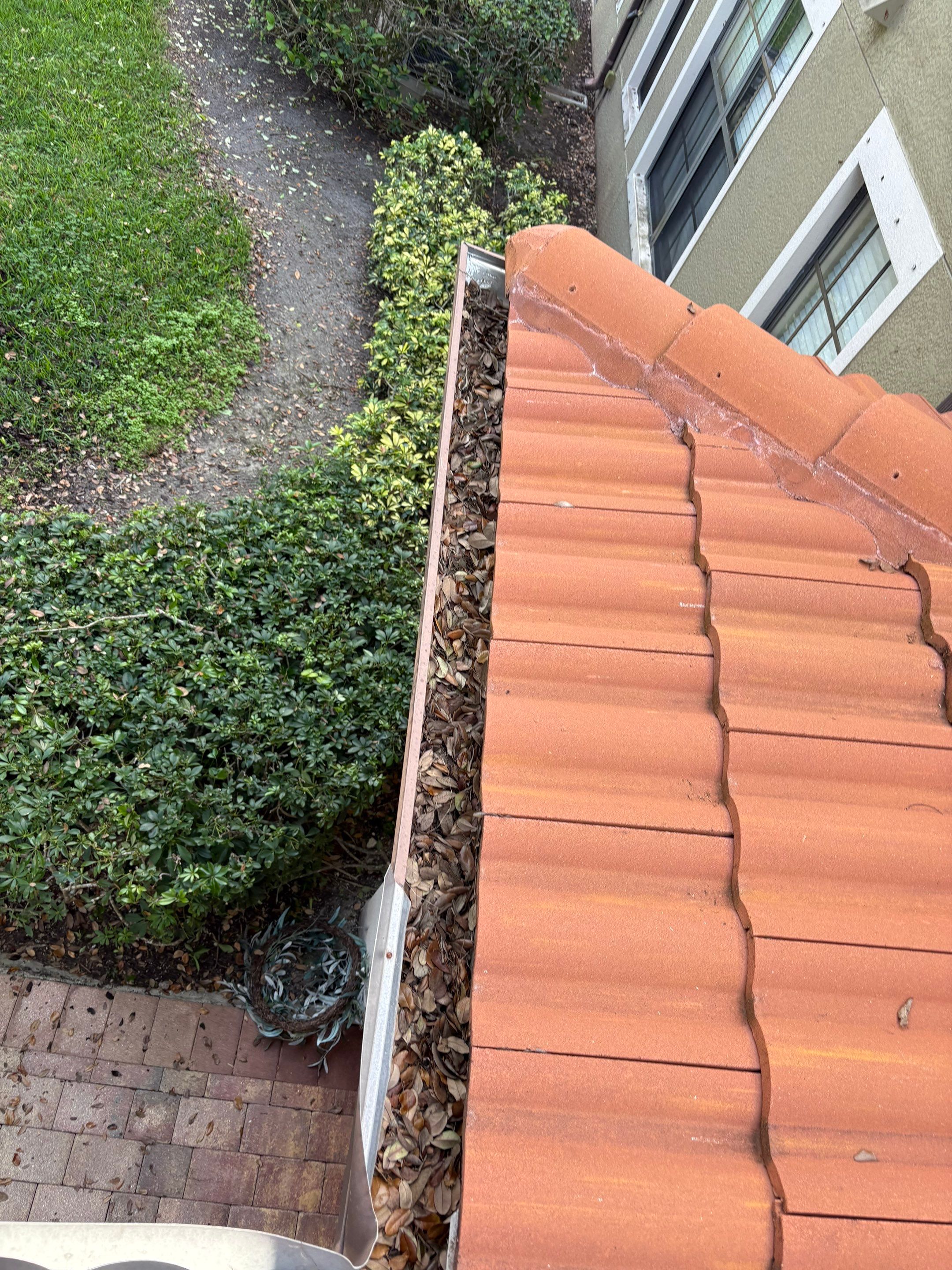 Commercial gutter cleaning Lehigh Acres & Bonita Springs, FL before photo with filled gutters