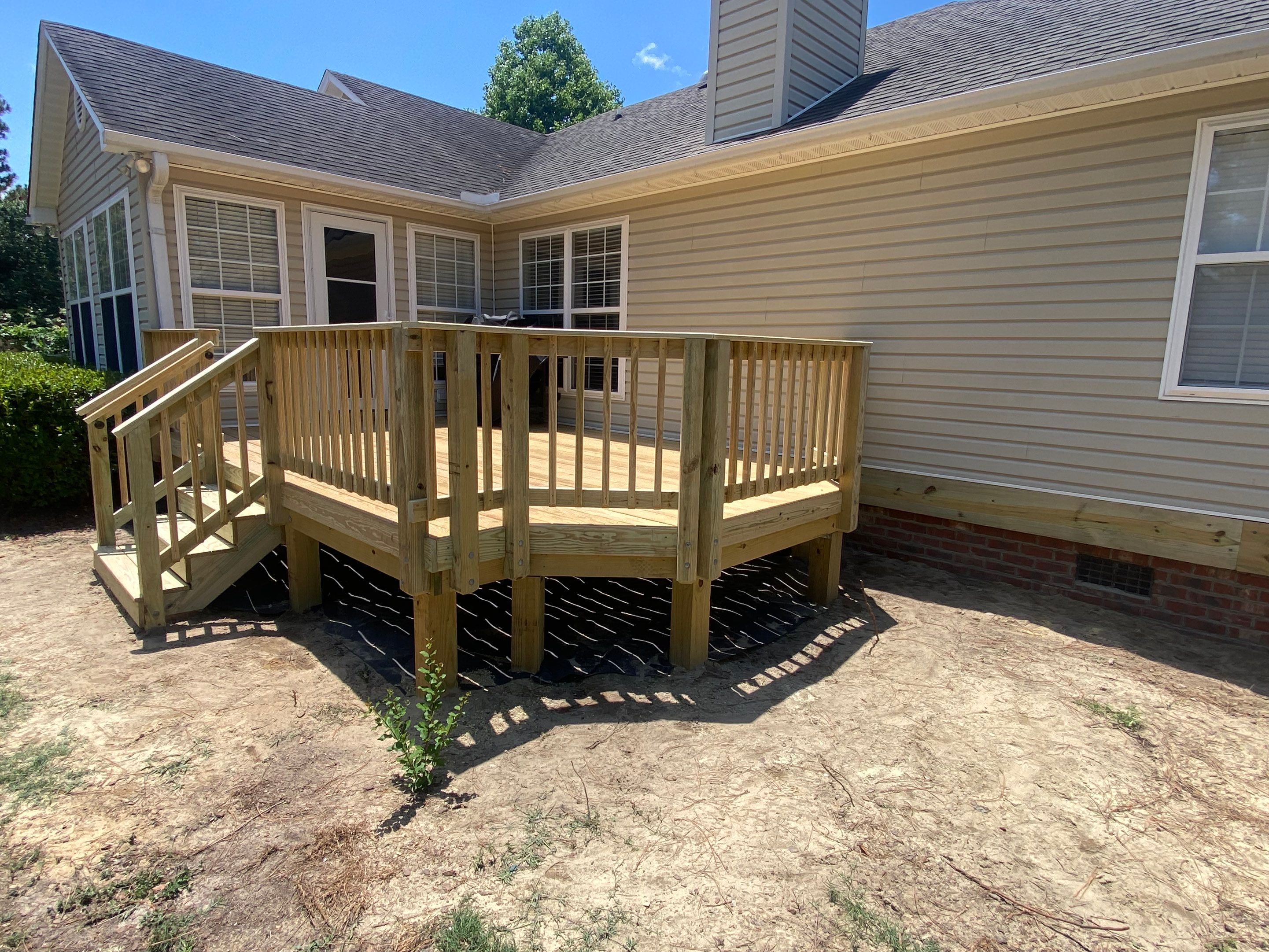 Custom Pressure-Treated Wood Deck with Central Stairs in Whispering Pines by The Remodeling Company