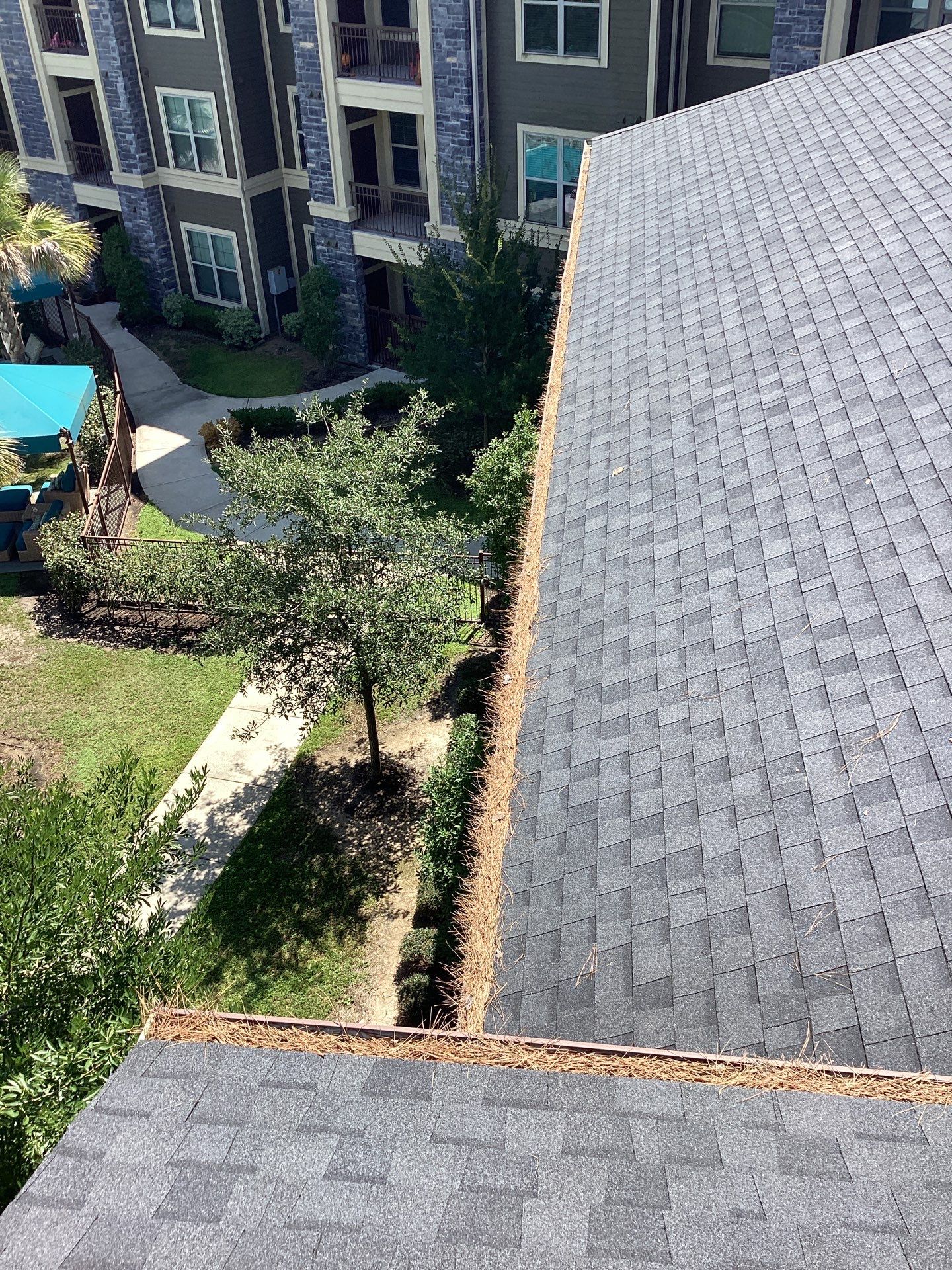 Commercial gutter cleaning Houston before photo with filled gutters