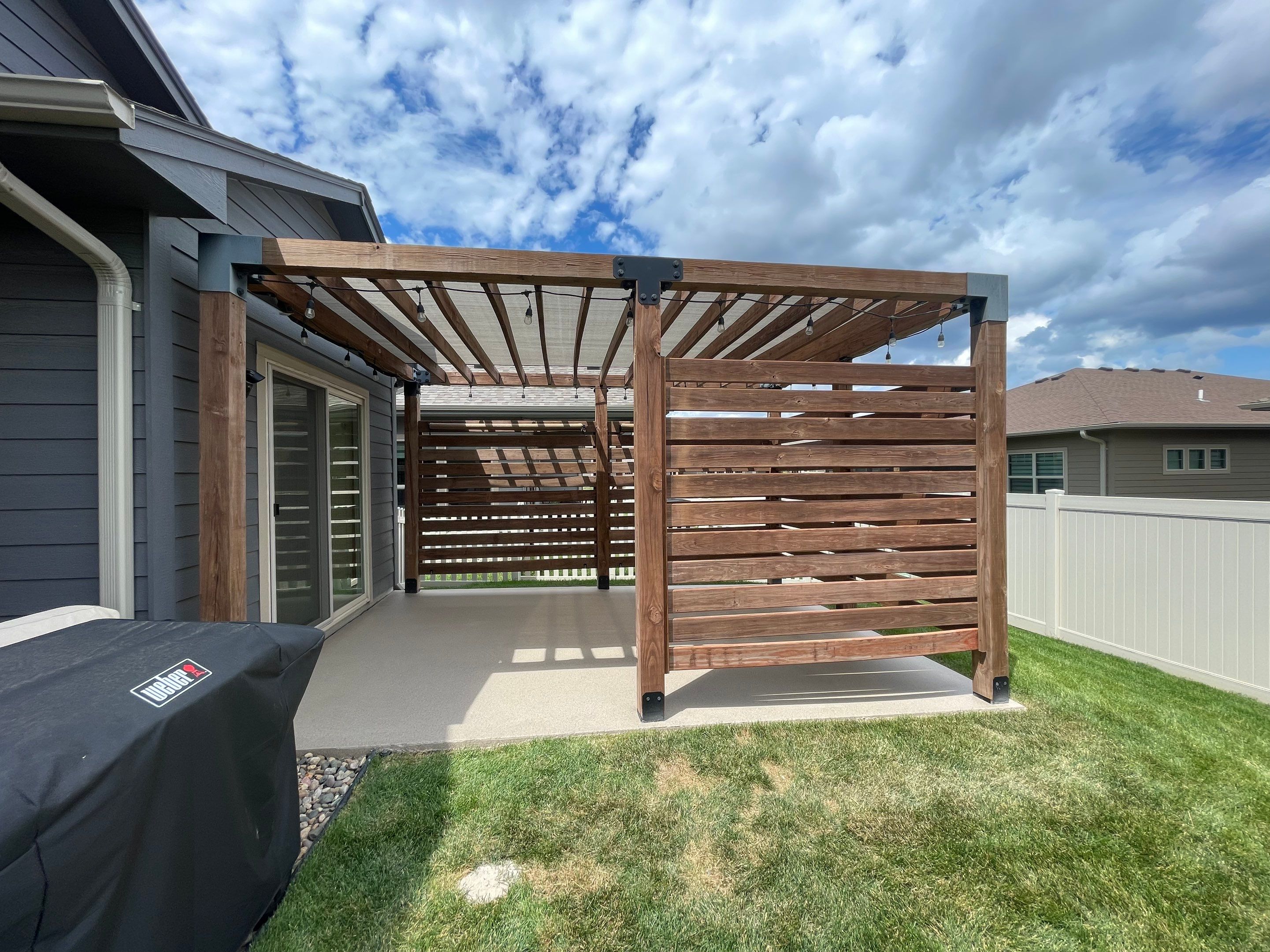 Textured Concrete Patio Coating and Custom Privacy Pergola in Sioux Falls by Select Painting, Coatings & Garage Cabinets