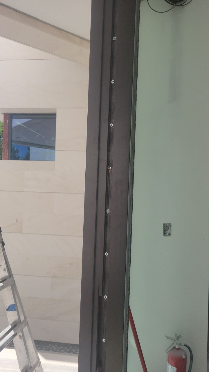 Custom Material Pivot Door installation by Impact Precious Wood Inc.
