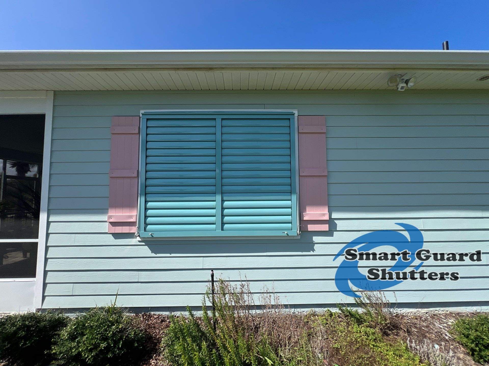 Impact Bahama Shutters in Pastel Turquoise by Smart Guard Shutters