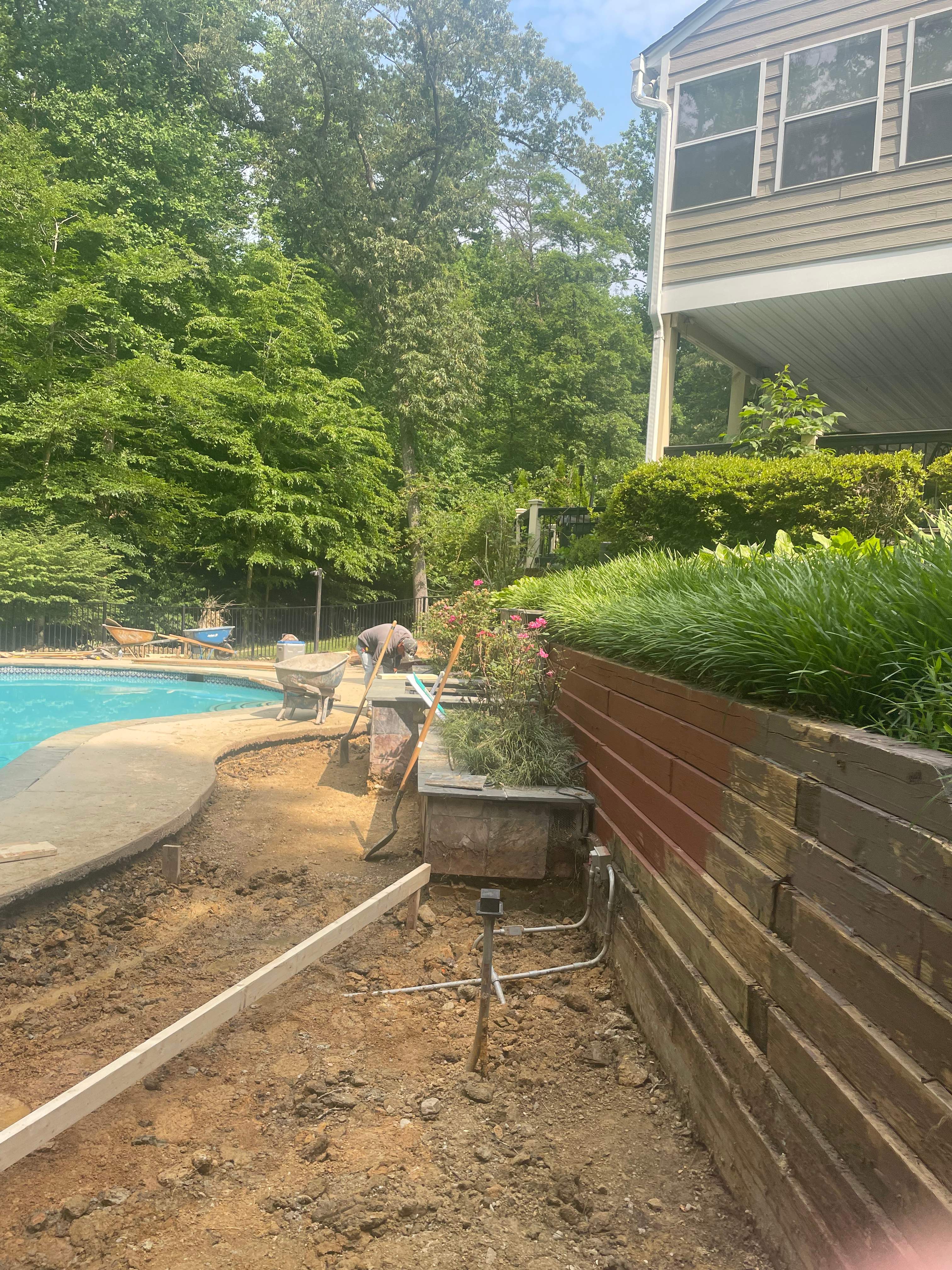 Pool Surround remodel with retaining walls, new waterfall and water slide by Fairfax Contractors, LLC