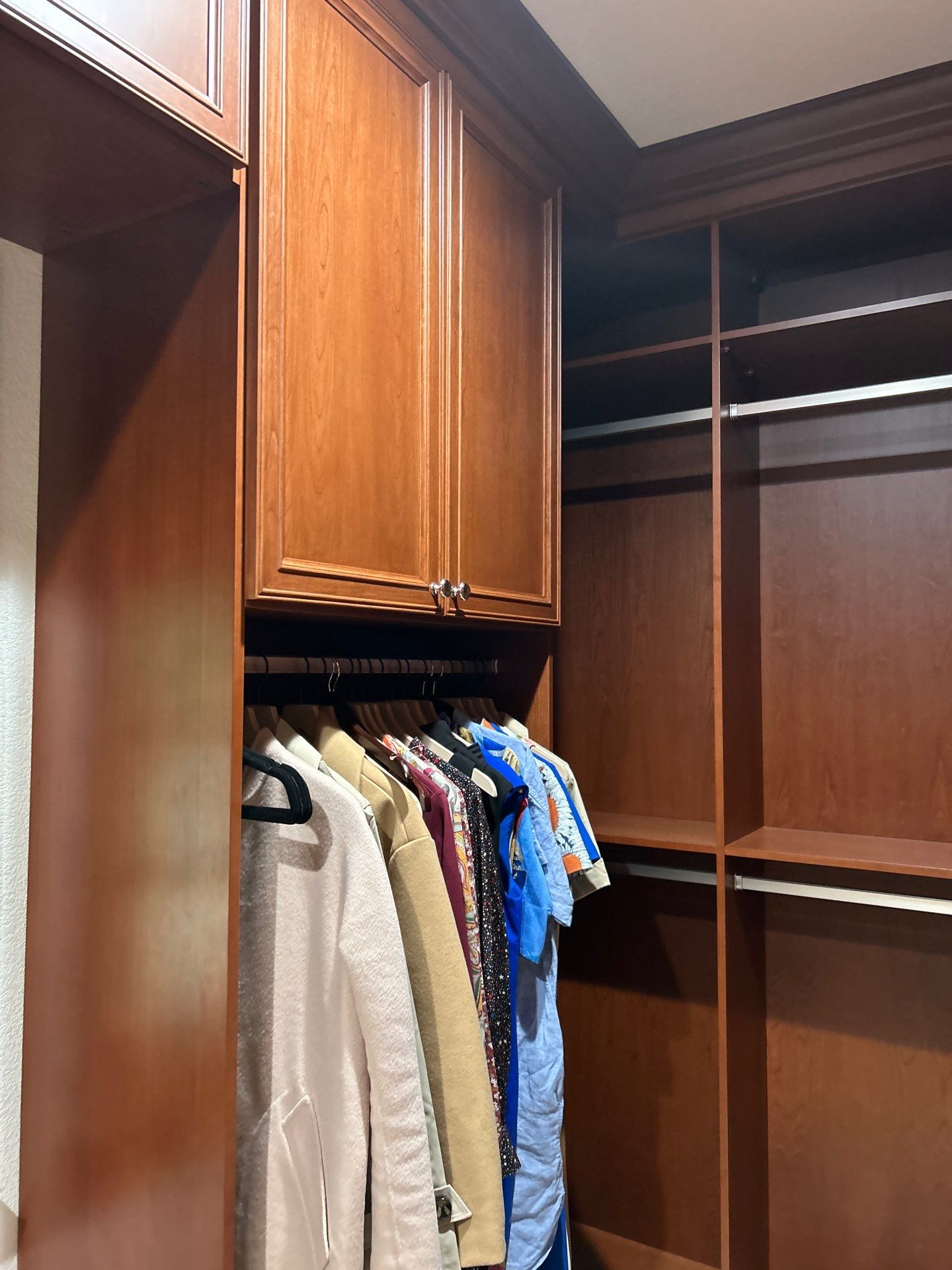 Stained Cherry Wood Primary Closet by Concept 32, Inc.