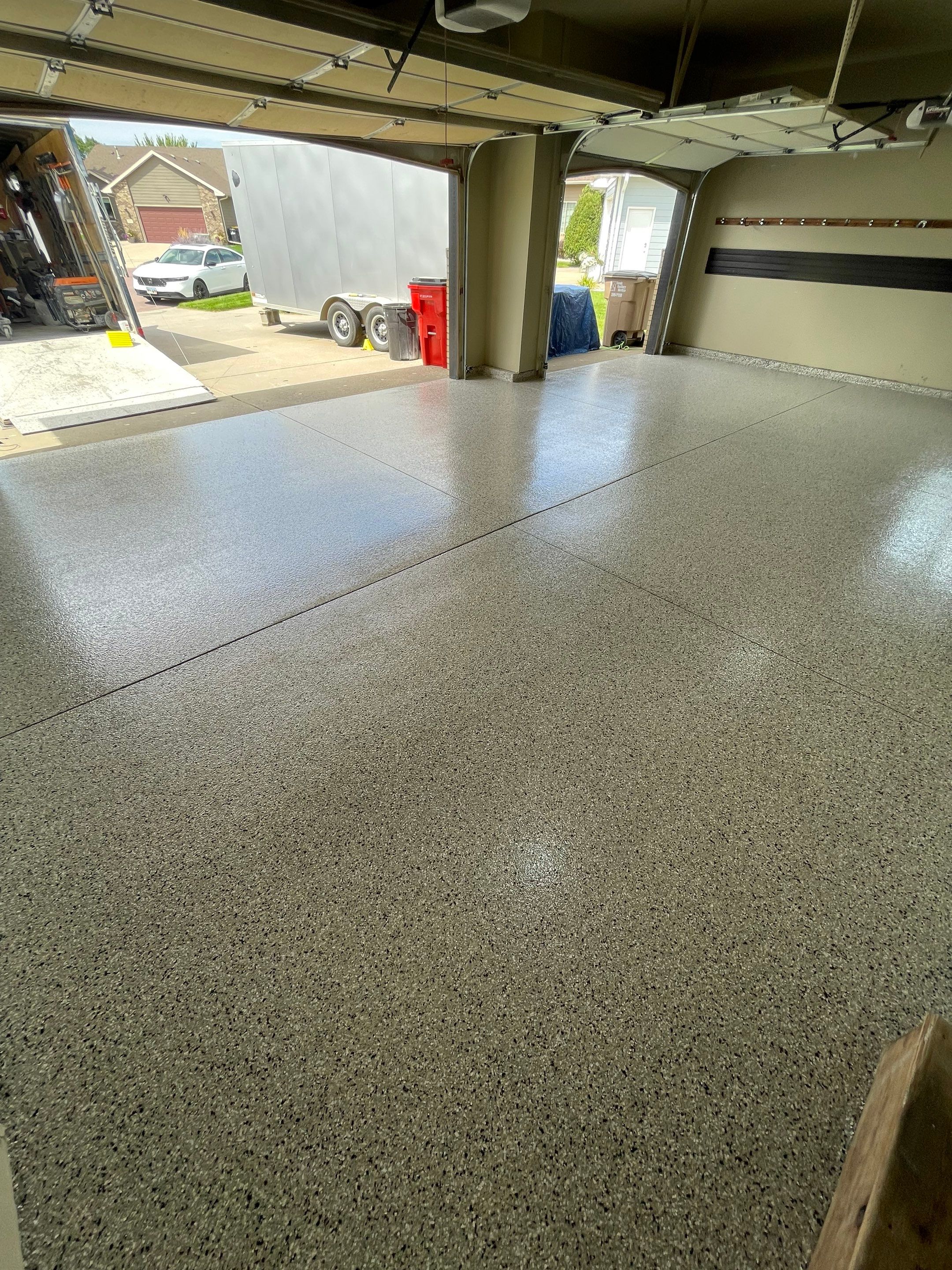Cabin FEver Flake Garage Floor Coating Installation in Sioux Falls by Select Painting, Coatings & Garage Cabinets