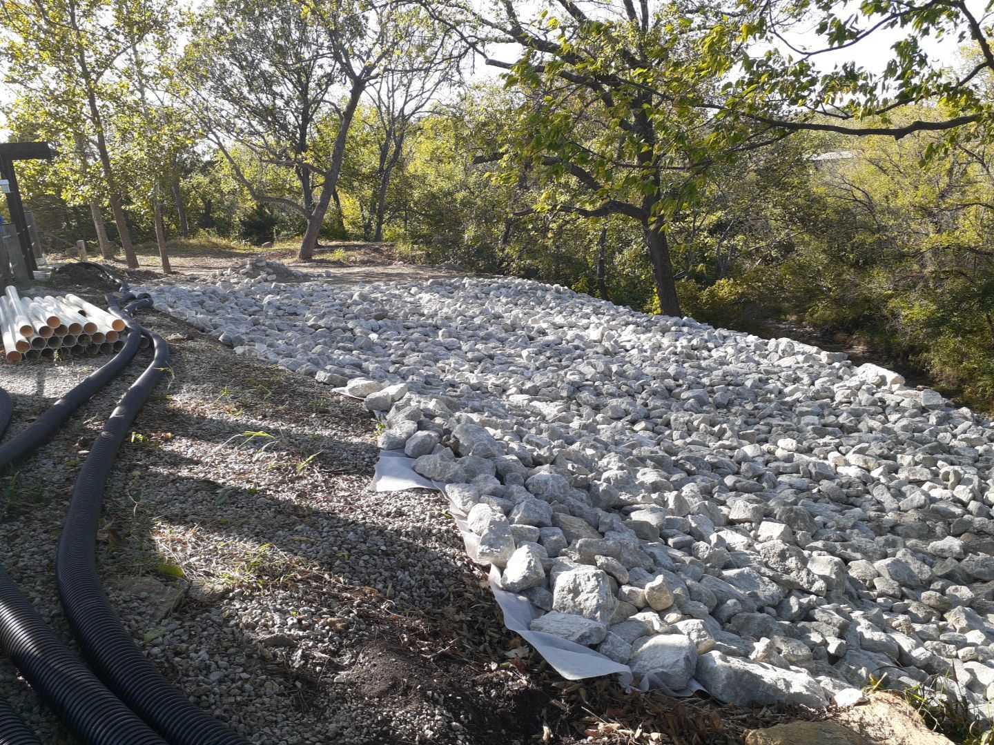 Supporting back of home with backfill at edge of steep creek by LAND ESCAPES LLC